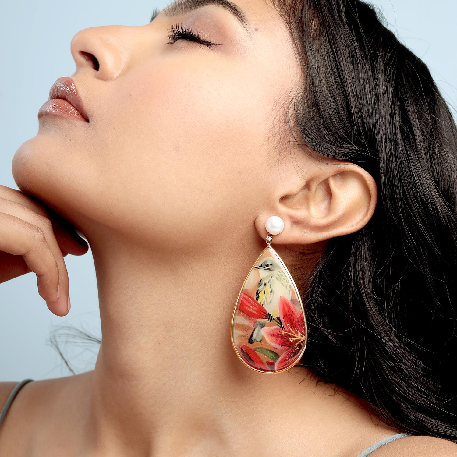 Ces boucles d'oreilles de la marque Artisan sont ornées d'un émail peint à la main sur 47,55ct de quartz cuit, de perles de 7,95ct et de 0,10ct de diamants, le tout serti dans 6,800g d'or 18 carats. Le spectaculaire design en forme de goutte d'eau