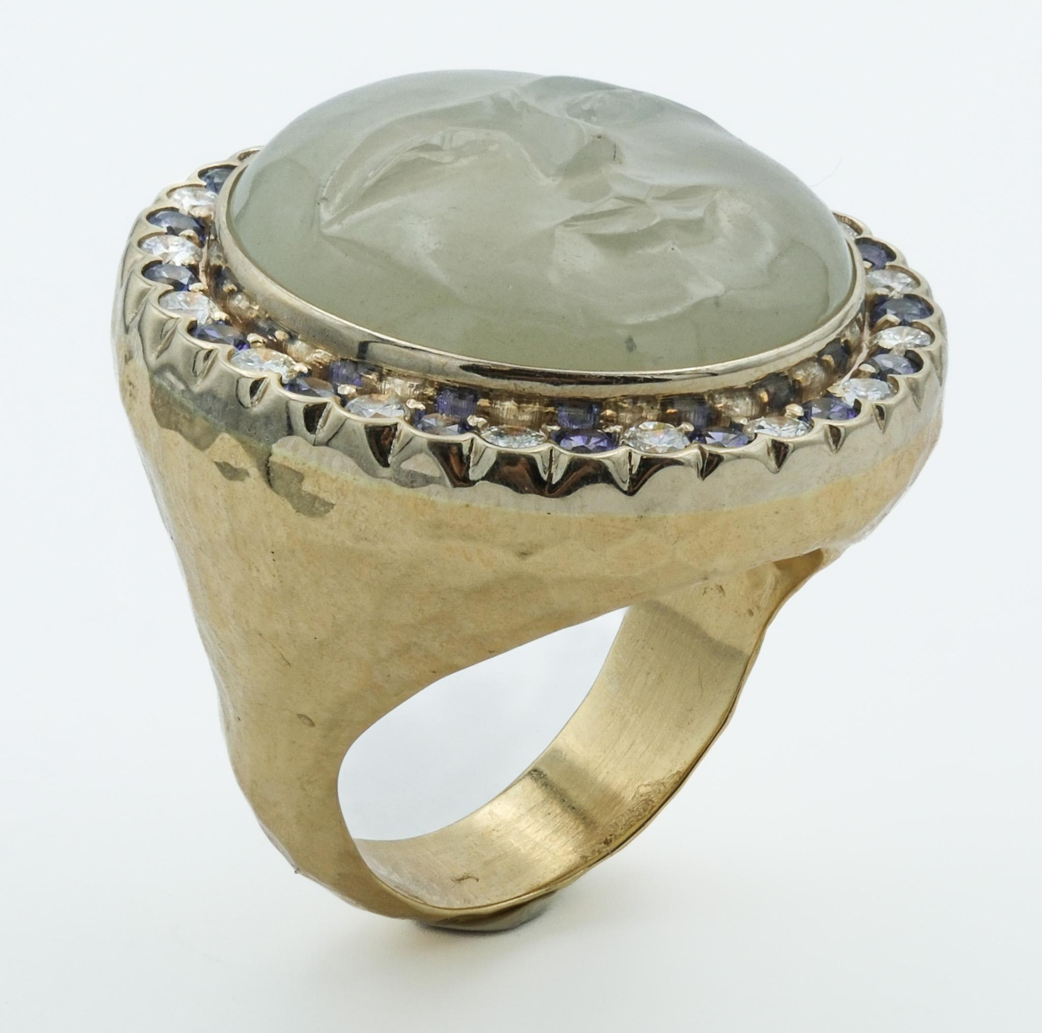This artisan-crafted ring is a unique masterpiece, blending whimsical design with luxurious materials. At its center is a beautifully carved moonstone face that exudes tranquility, with a serene expression and soft, ethereal glow. The moonstone is