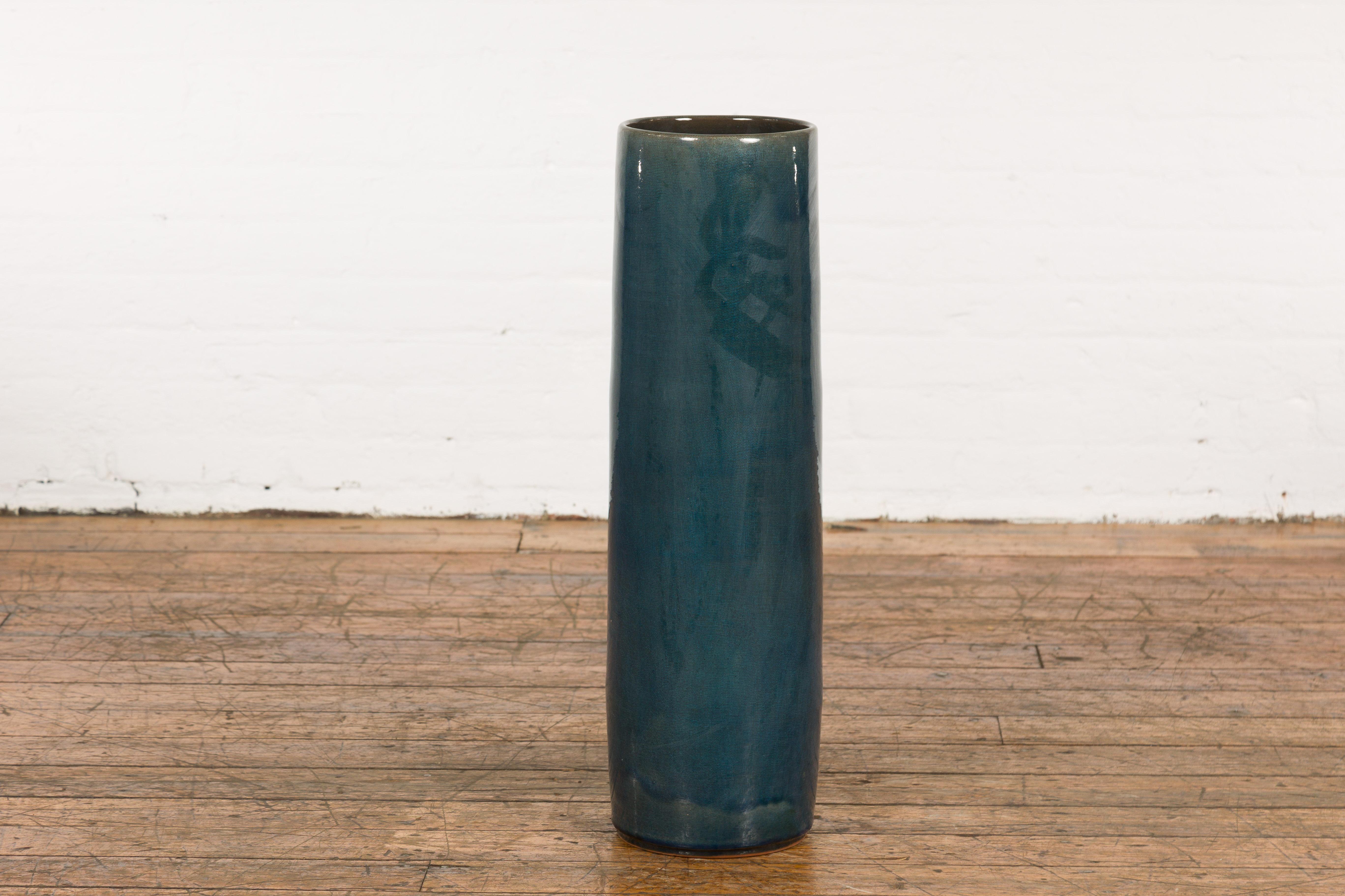 A Prem Collection ceramic handcrafted artisan floor vase with blue textured finish. Showcasing sleek lines and a blue green colored finish, this Prem Collection ceramic handcrafted artisan floor vase will bring an undeniable decorative interest to