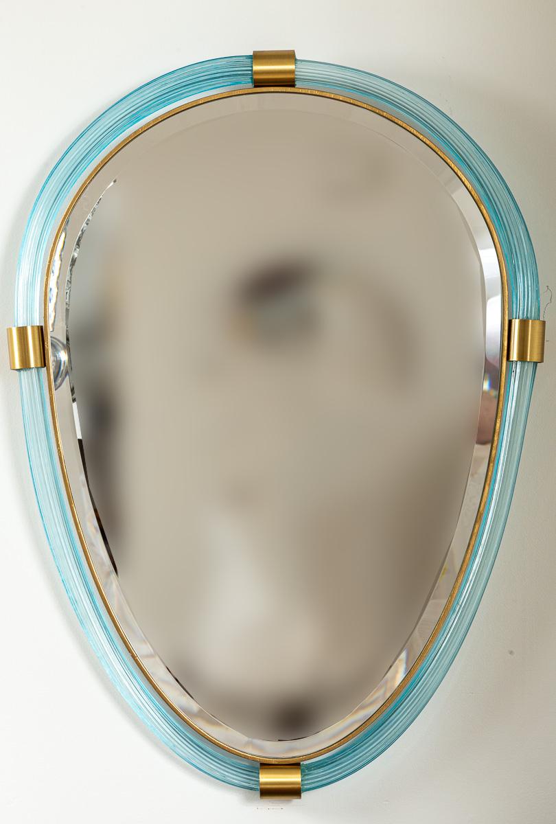 
Verre soufflé de Murano  aigue-marine transparente  torchère  tubes reliés par des raccords en laiton non laqué pour former une belle forme ovale  miroir avec glace biseautée

Origine : Murano, Italie

Condit : Très bon

Datation : Contemporaine,