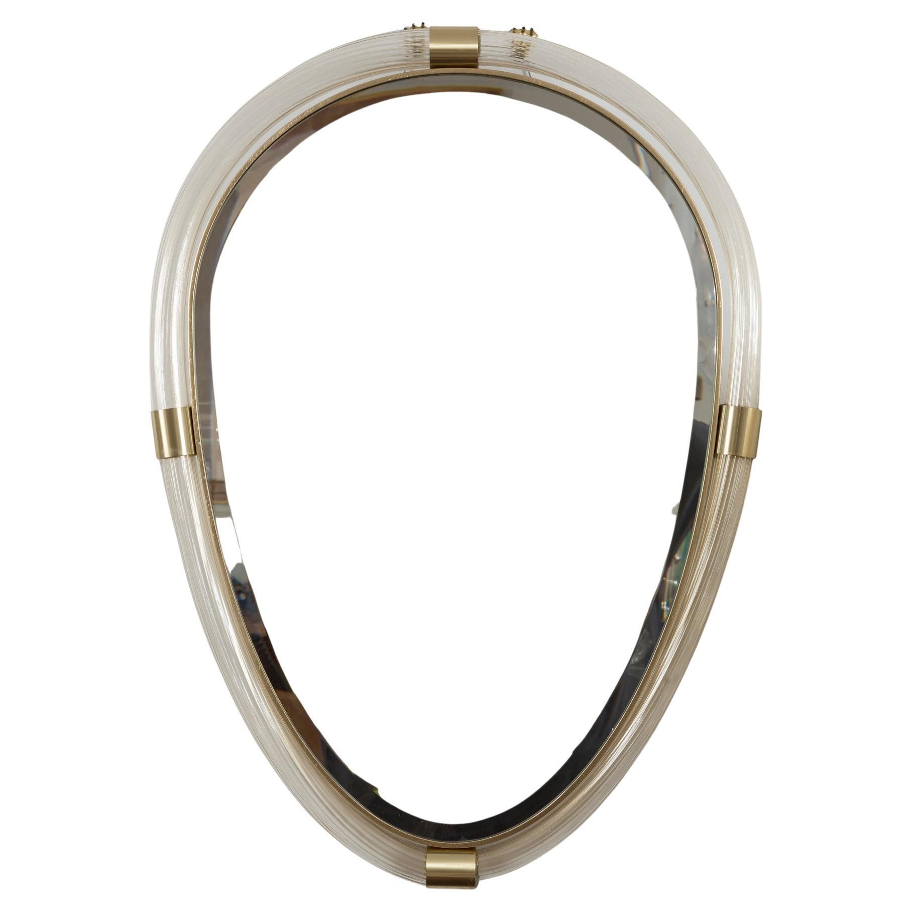 Murano glass blown transparent and 23K gold reeded torchere tubes joined by unlacquered brass fittings to form a lovely oval shaped mirror with bevelled looking glass. This new style is inspired by the Art Deco Barovier Mirrors from the 1940s but