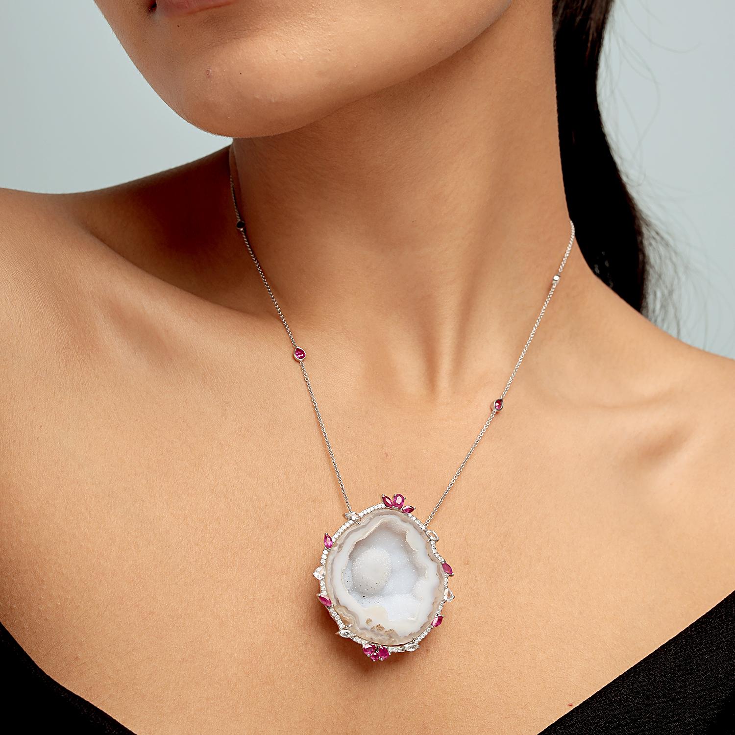 Questa collana unica di Artisan mette in risalto uno splendido geode naturale da 79,12 carati, incorniciato da rubini da 2,63 carati, zaffiri da 0,75 carati e diamanti scintillanti da 0,43 carati, il tutto incastonato in 9,254 g di oro bianco 18