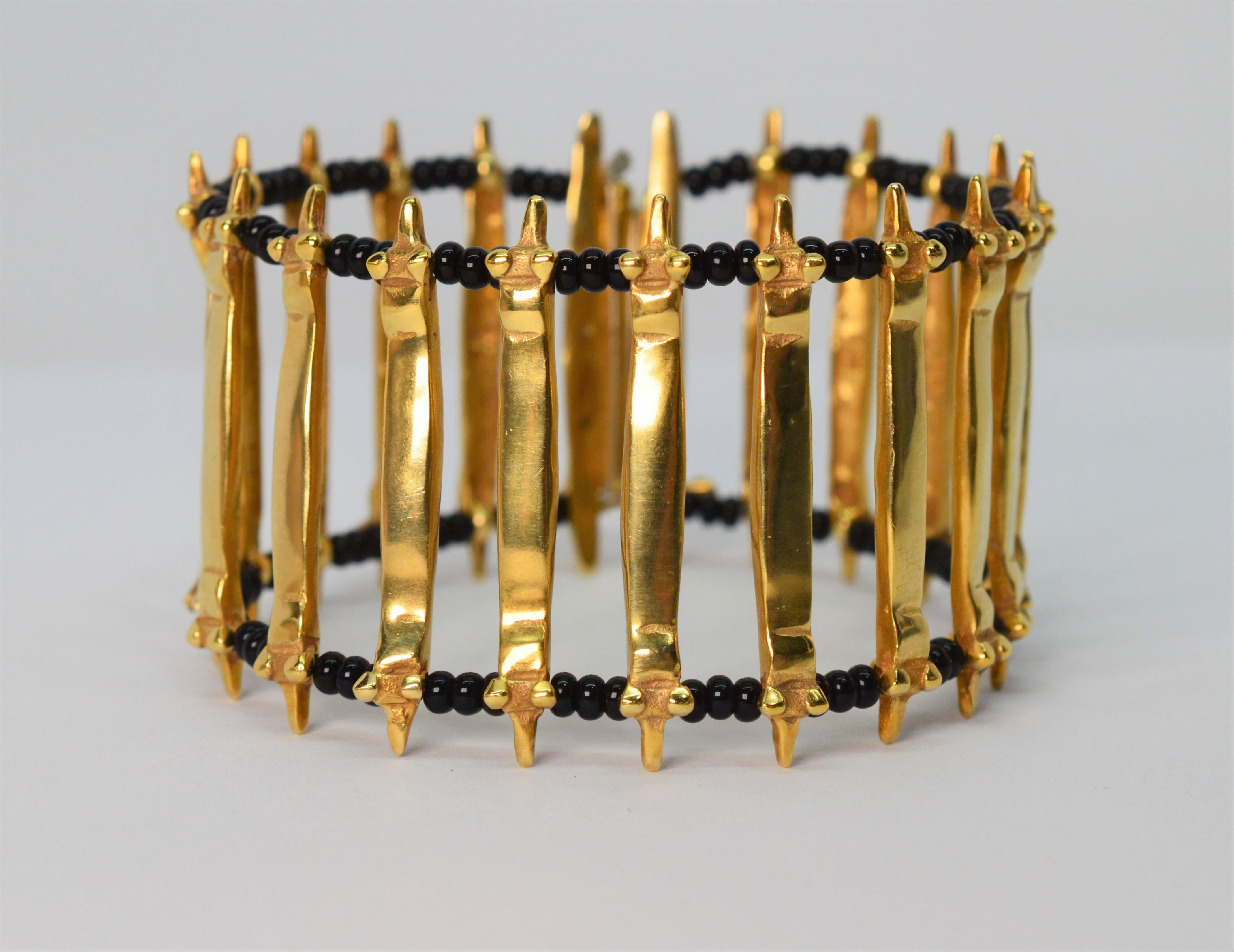 Craftsman overtones give this eighteen karat 18K yellow gold bracelet its unique rustic style. Architecturally inspired cast and hammered gold links are woven in a ladder pattern with contrasting black onyx beads to create a dramatic and defined