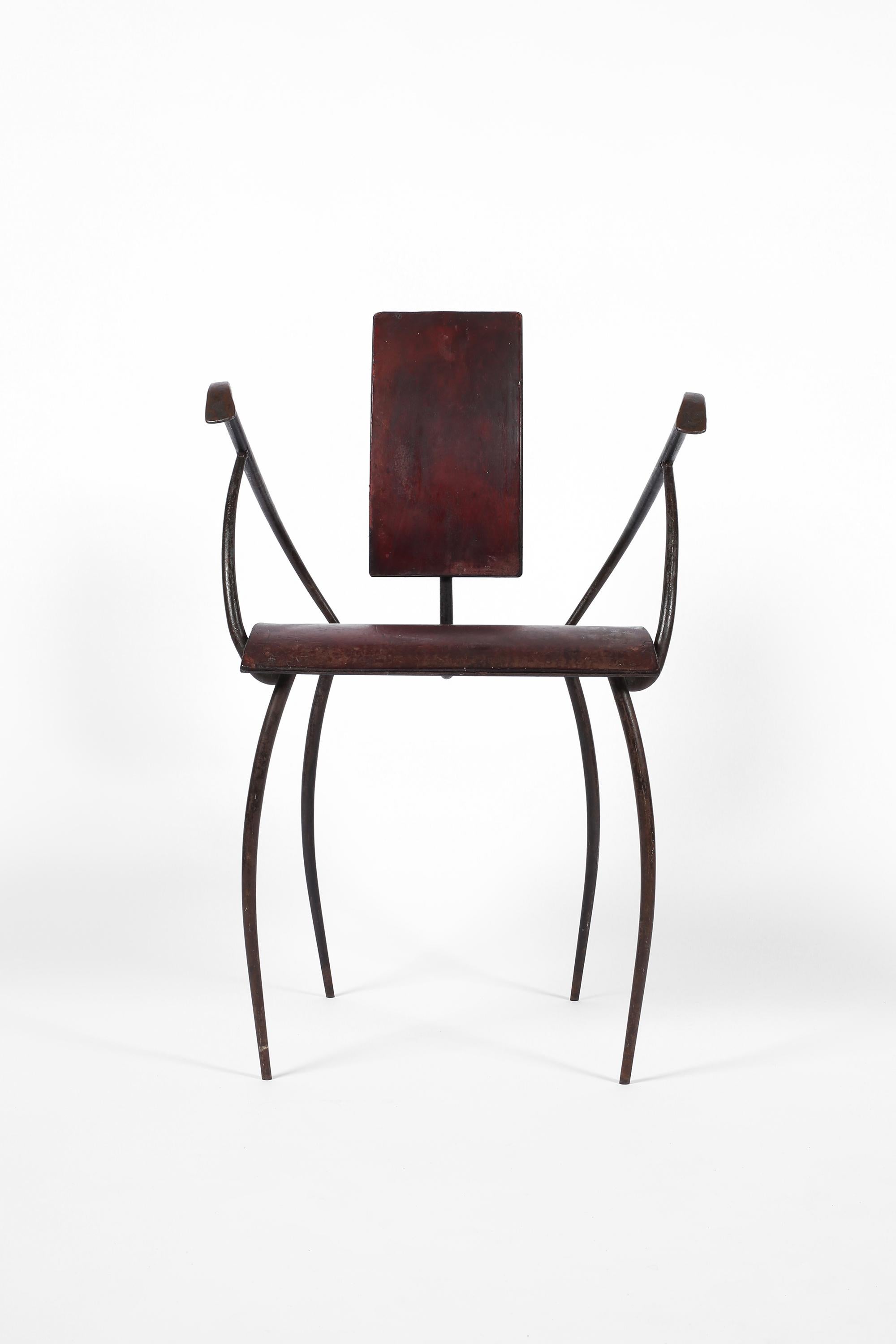An artisanal modernist occasional chair in wrought iron, with patinated oxblood leather clad seat and backrest. French, c. 1940s.