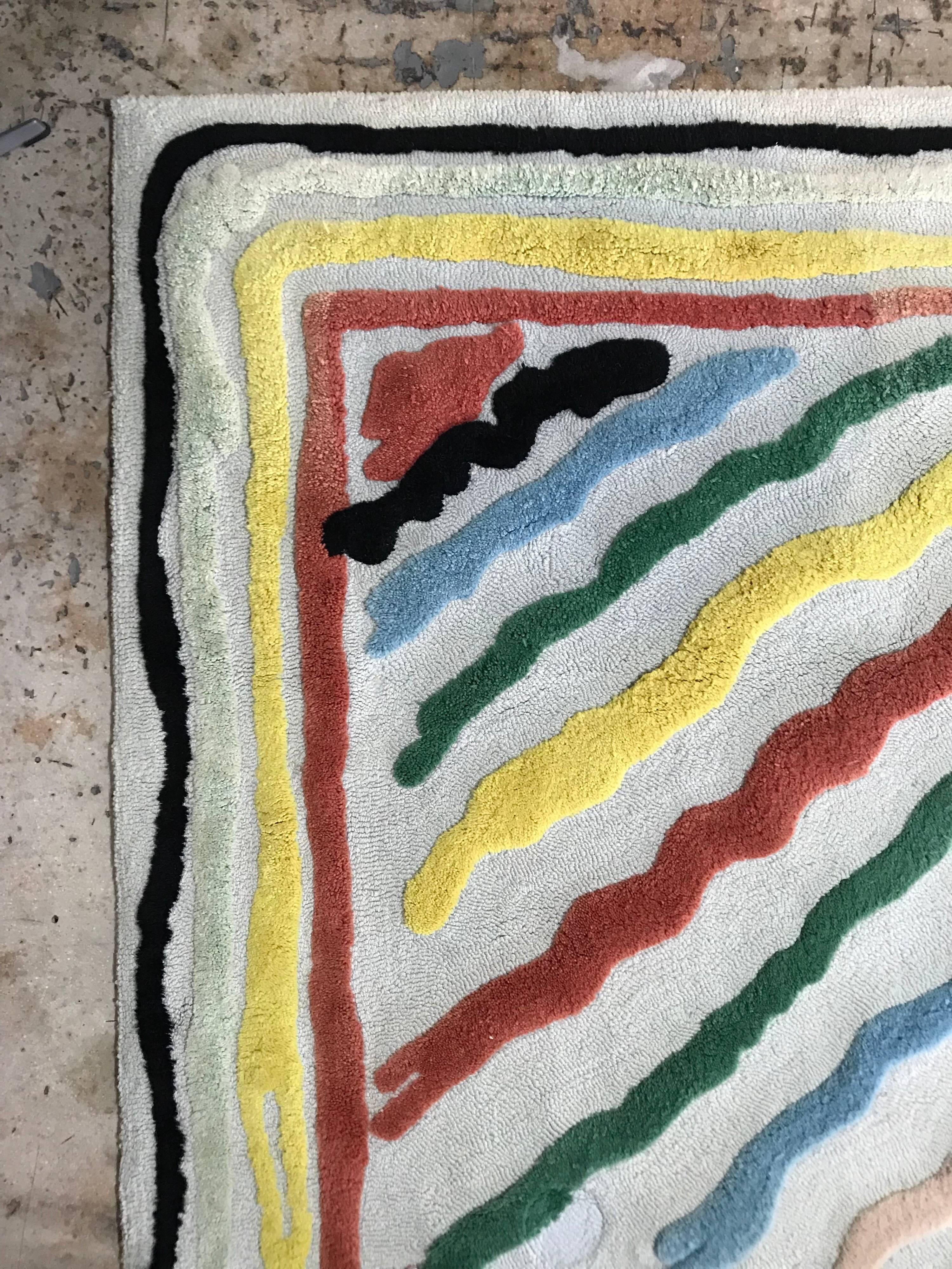 Colorful wool rug with two different pile heights and borders in the style of Edward fields rugs, signed by artist.
Measures: 9’ x 12’.