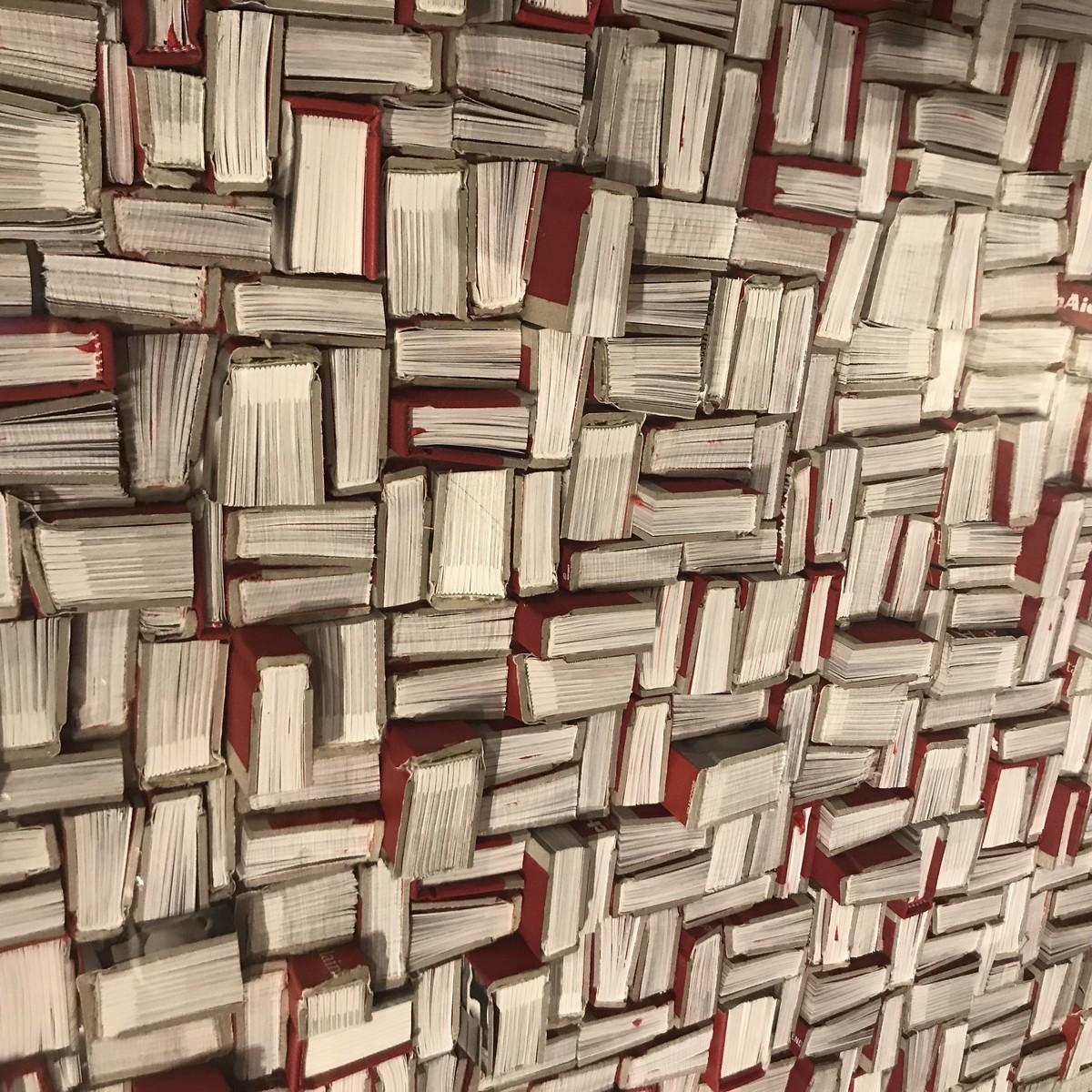 Contemporary Belgian artist Guy Leclef creates a paper wall sculpture by
cutting red bound books placed to create a unique design
Pieces are stacked horizontally and vertically and housed within a lucite box