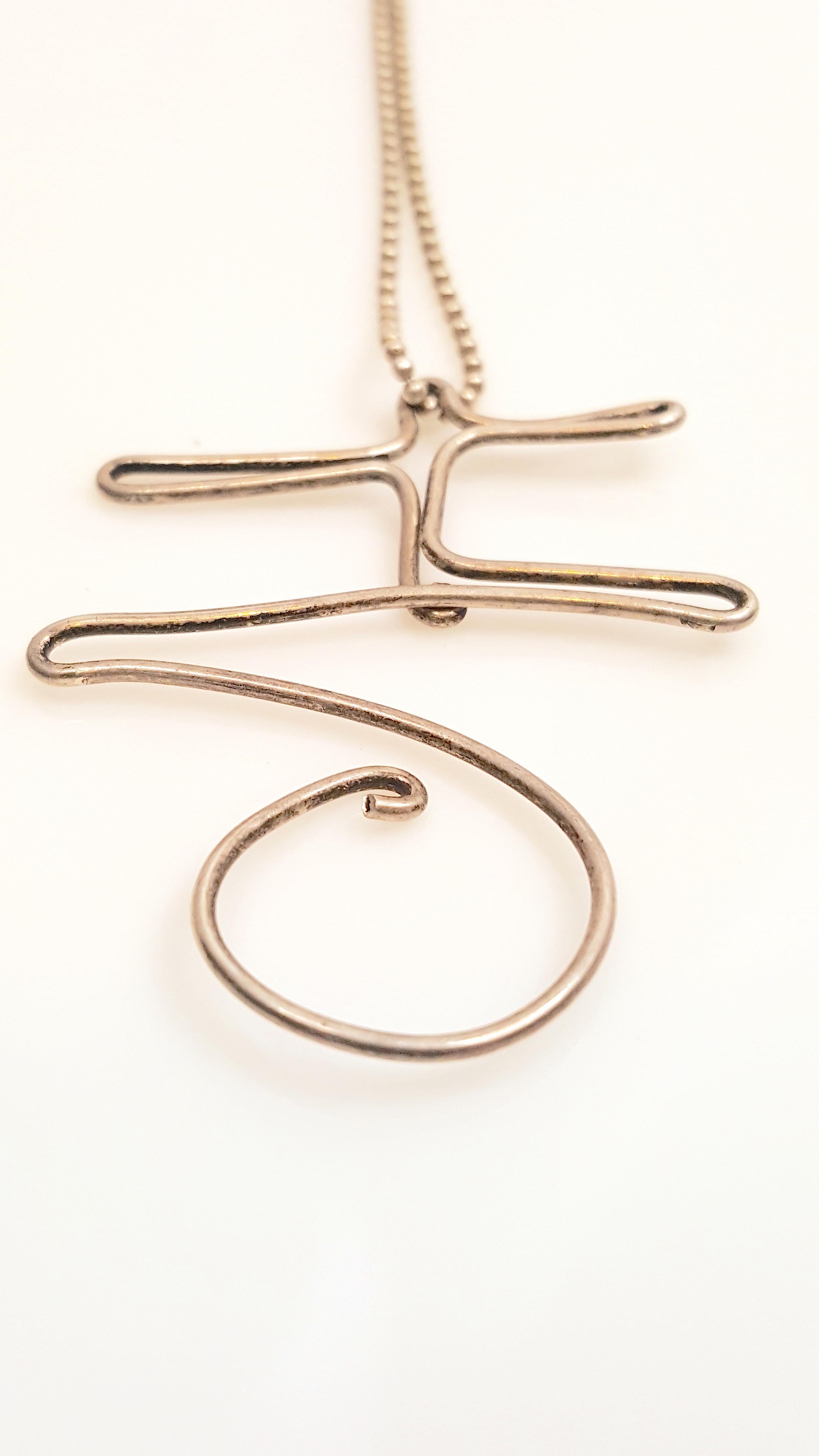 Like Alexander Calder's handmade wire jewelry since 1929, whose smallest one-of-a-kind sculptural subjects ranged from aerial acrobats and dancers to monograms with letters representing a friend, this modern minimal sterling-silver wire pendant was