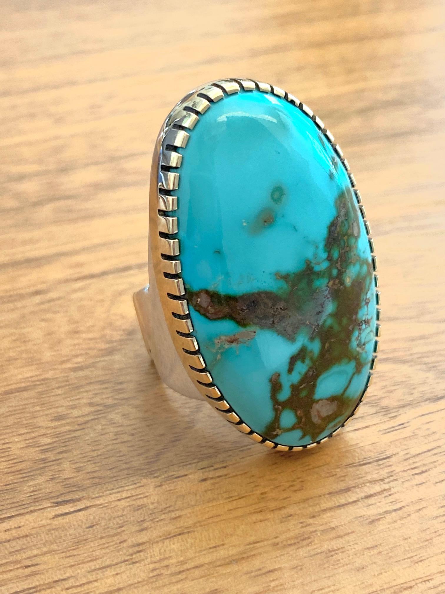 A silver ring with gold bezel encasing a large Royston turquoise by Verma Nequatewa, c. 2018. Hopi. Stamped Sonwai, and maker's mark. Artist Jewel. 
Ring size 7. This ring measures 1.75
