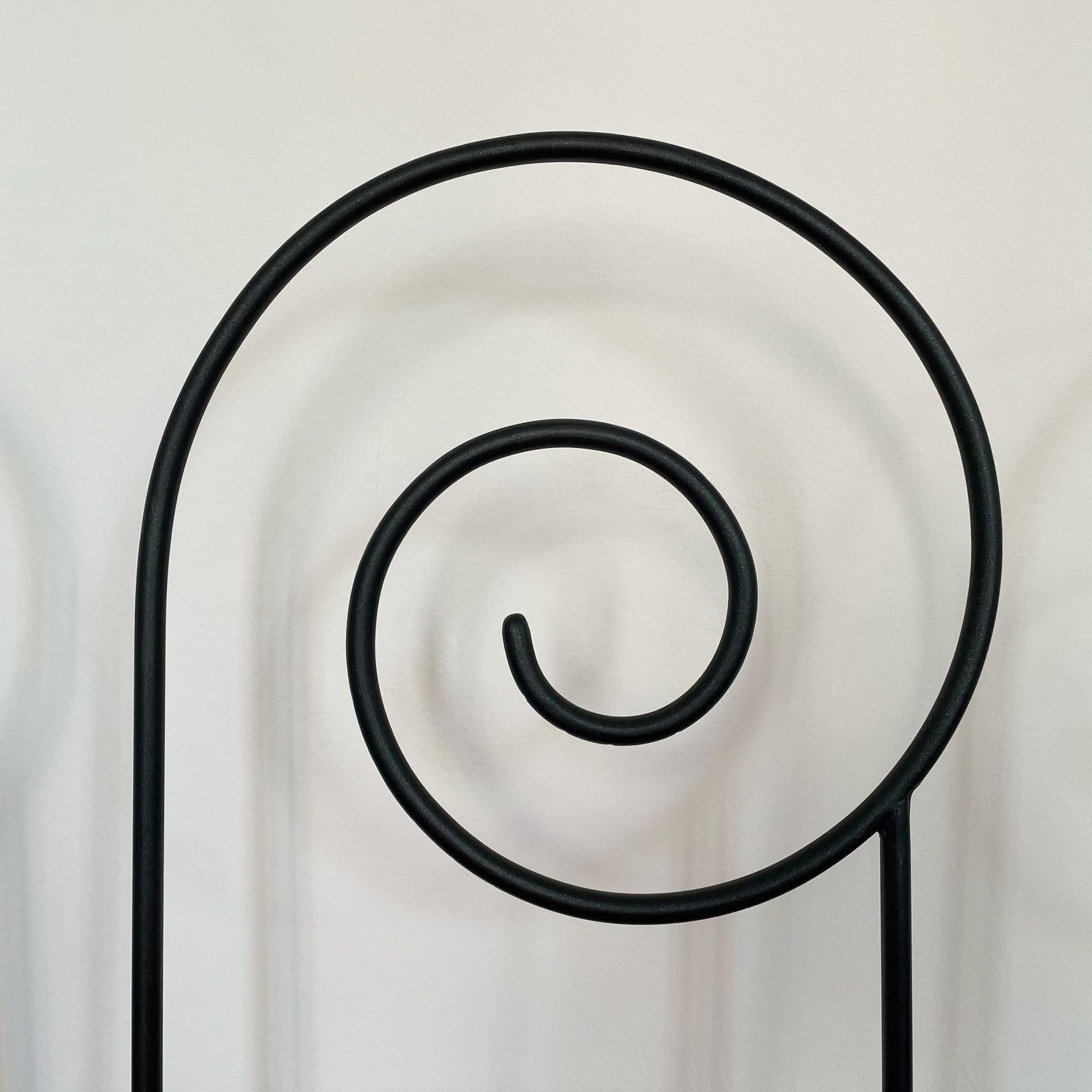 Artista Luigi Serafini, Cuatro sillas colgantes de acero negro 
Cada silla está tapizada en un color diferente de tapicería de Algodón.
Blanco, Negro, Verde y Rojo.
