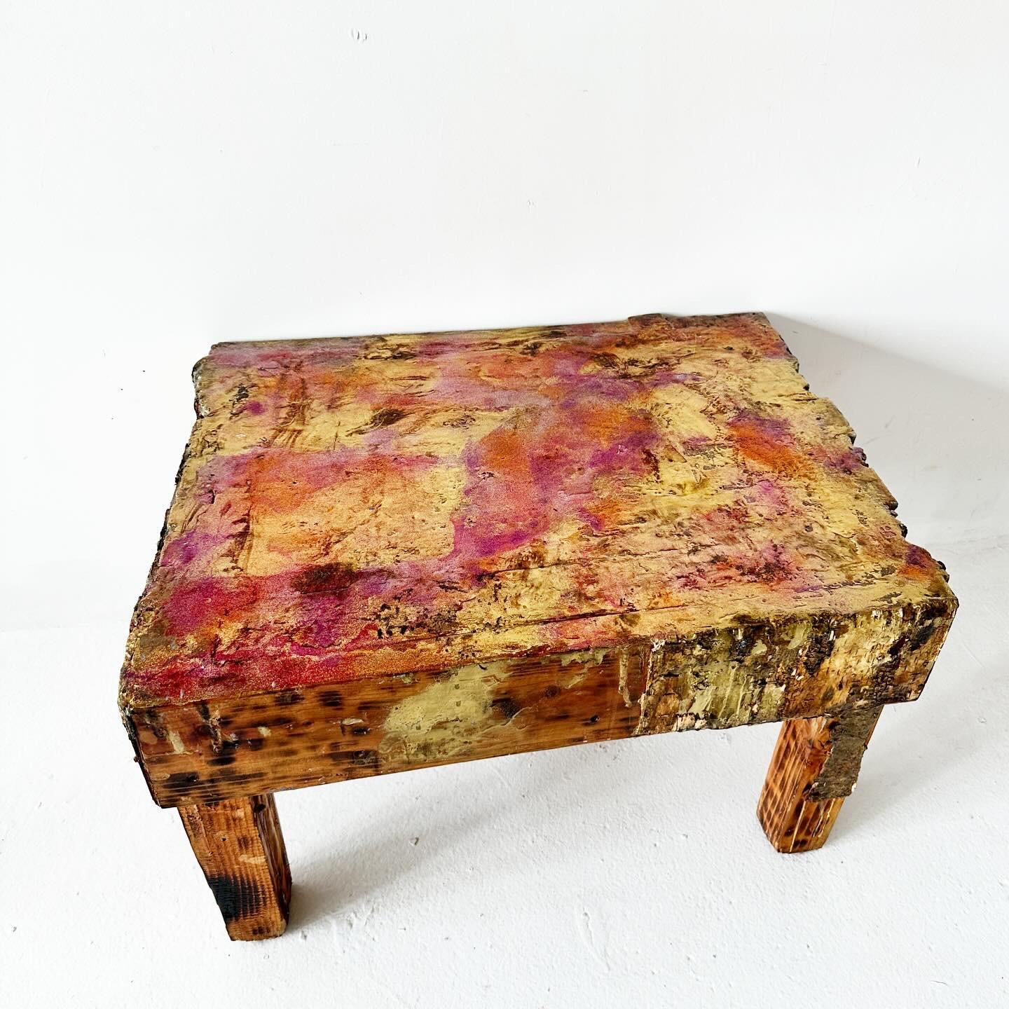 one of a kind, artist made, brutalist coffee table or side table. Solid birch (with bark accents and burn marks), glossy surface with gold and magenta under lacquer. Really wild, I love it.