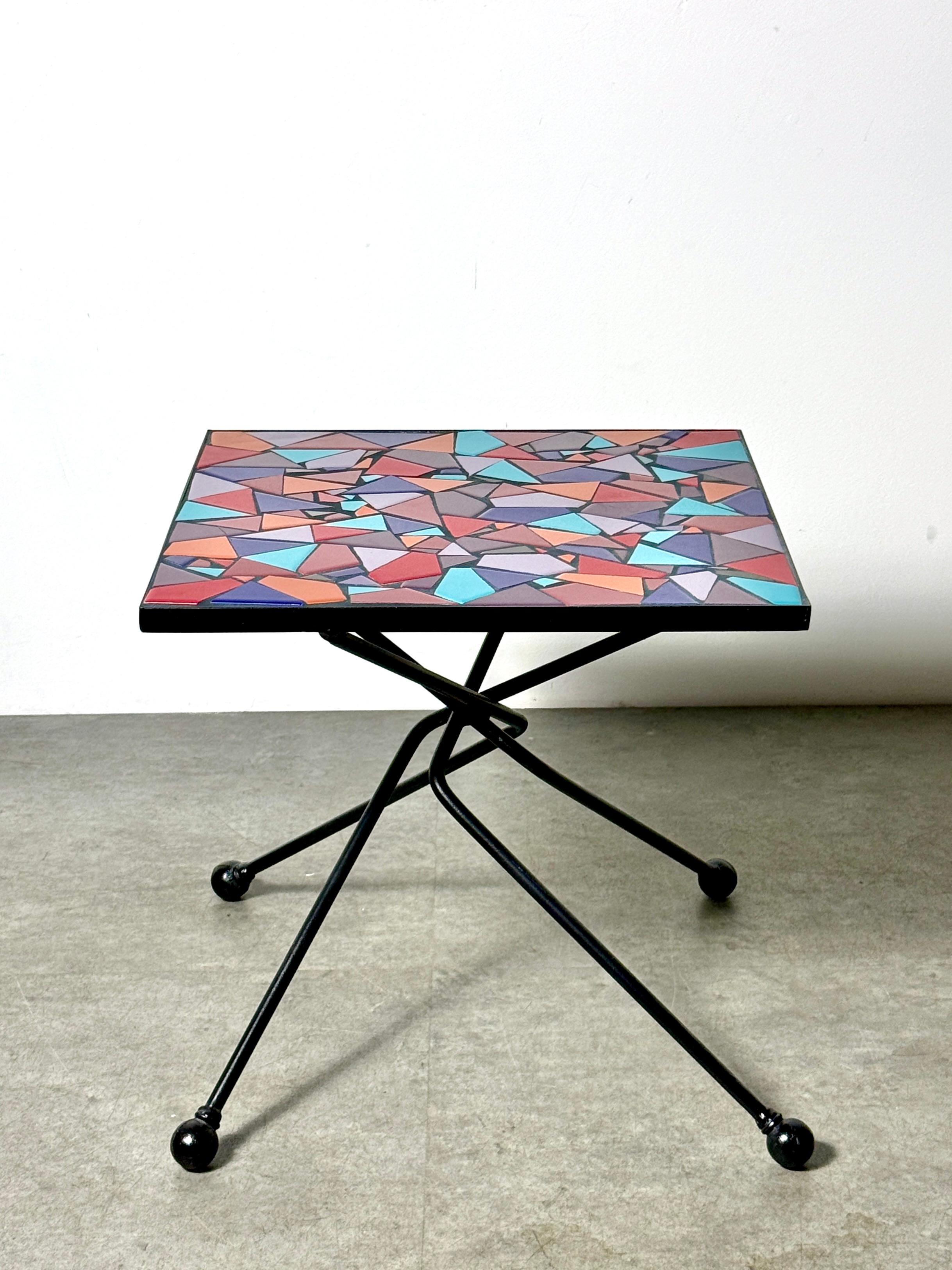 Table d'appoint unique faite par un artiste avec un plateau en mosaïque géométrique 
Circa 1990's

Surface de mosaïque incrustée de carreaux de céramique à angles vifs dans une palette de couleurs vibrantes donnant un aspect presque vitrail.
Base en