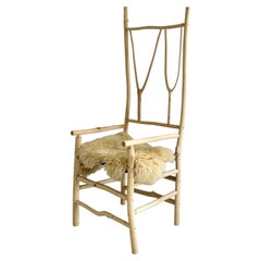 Silla alta de ramita hecha a mano por artistas Studio Craft + asiento de tablero de ajedrez tejido + piel de oveja