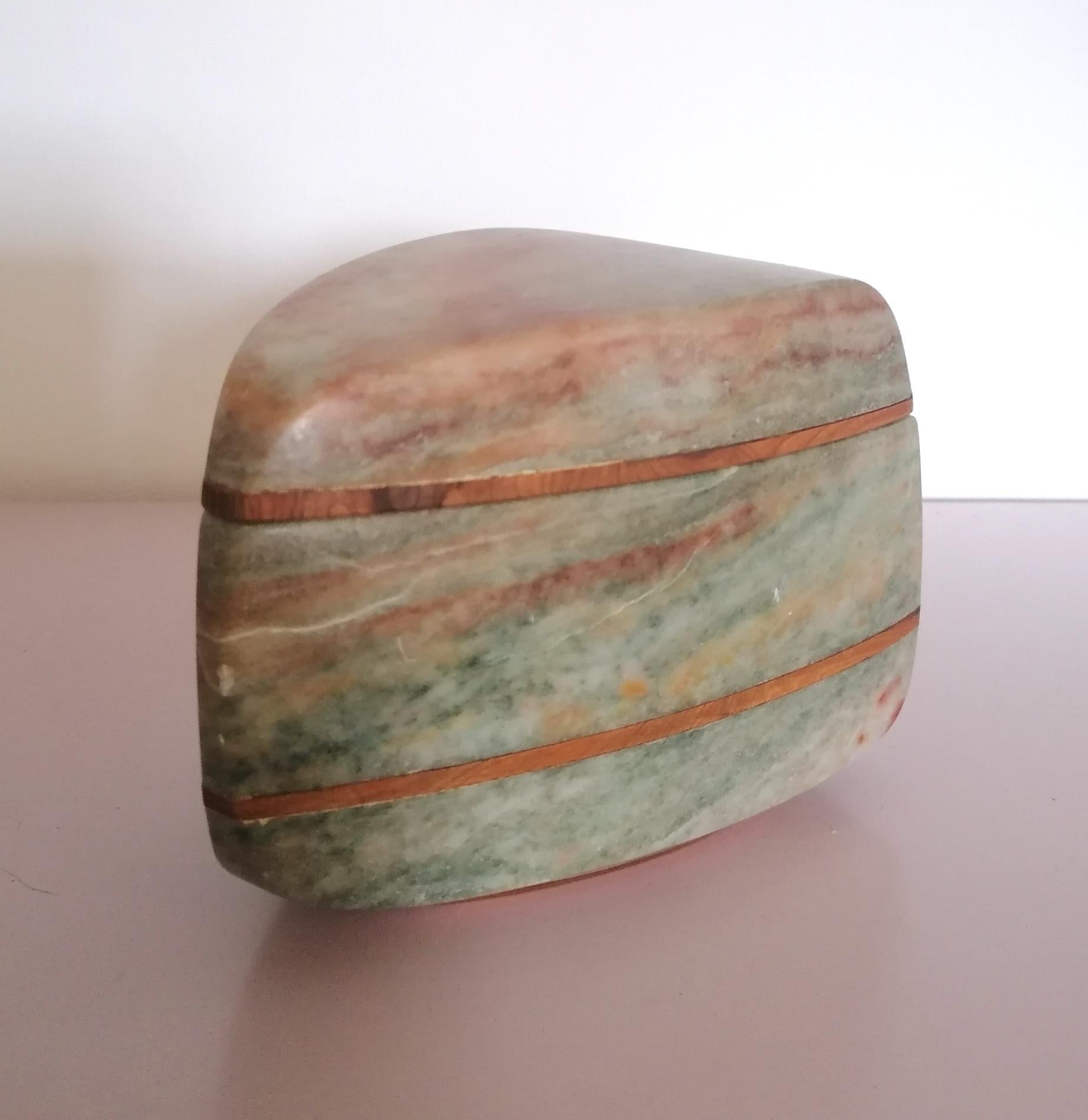 This beautifully tactile sculptural onyx lidded box is a unique artist-made piece...unfortunately I've been unable to identify the maker's mark. We sourced it in Phoenix, Arizona.
Bands of walnut are inlaid in the stone body, and walnut lines the