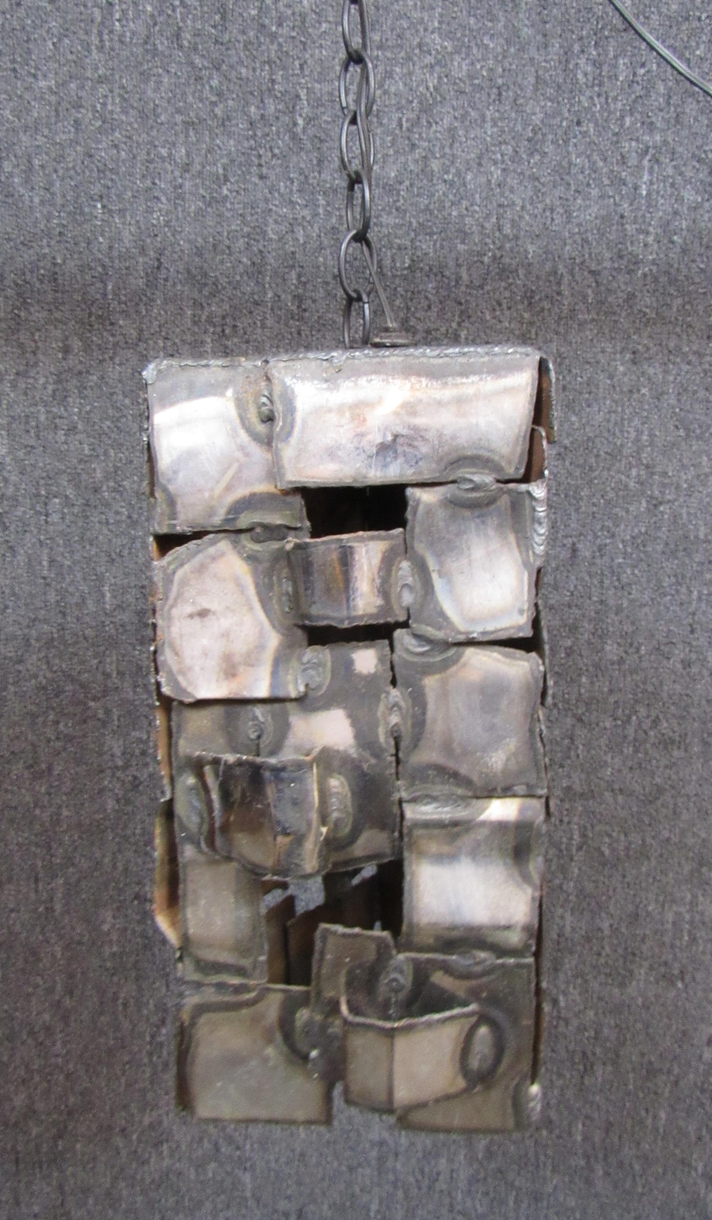 Brutalistische, selbstgebaute Hängeleuchte aus geflochtenen Metallstreifen. Dreieckige Form mit einfacher Steckdose.
Bitte bestätigen Sie den Standort NY oder NJ