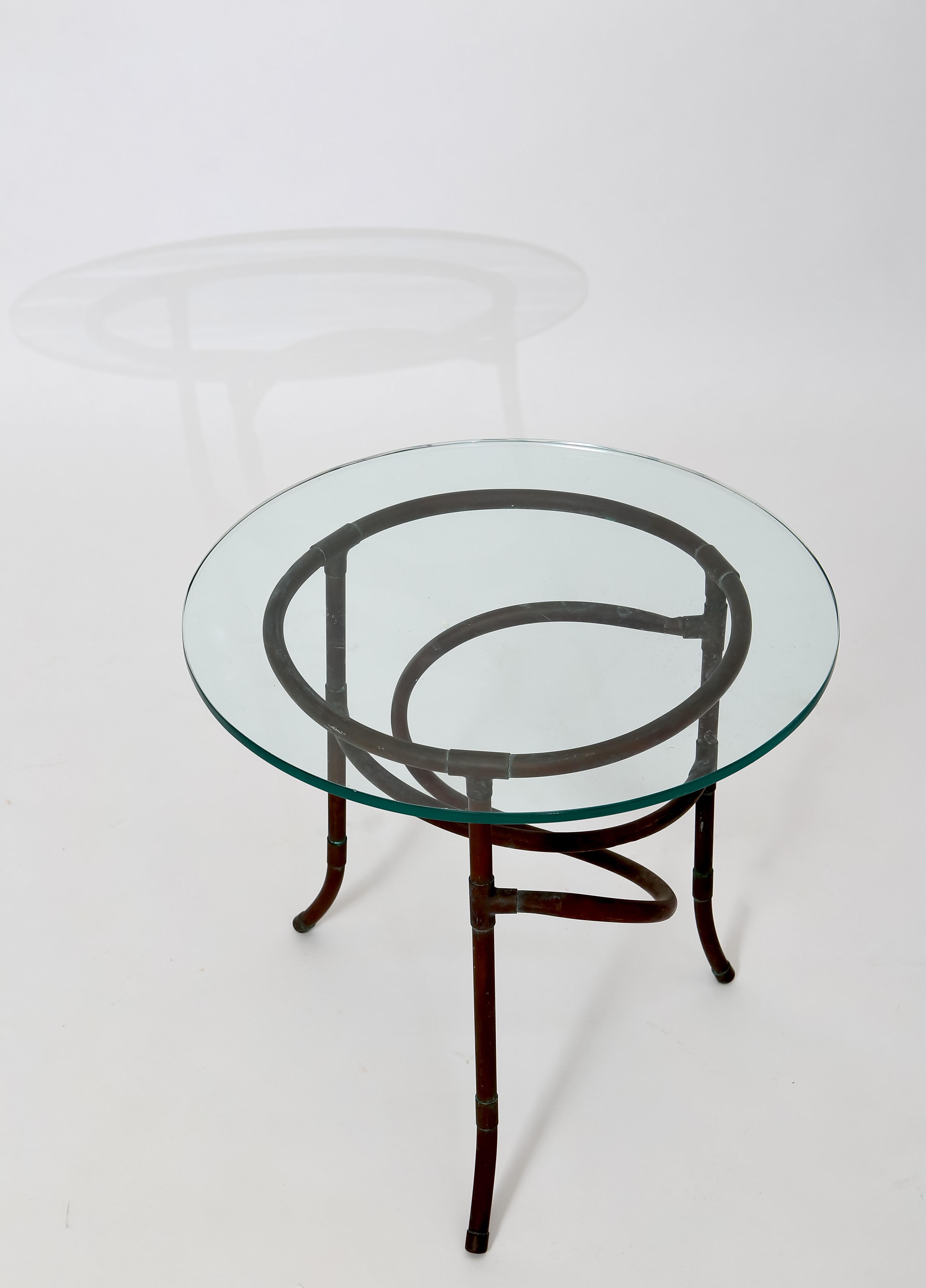 Constructed of copper tube, this interestingly sculptural accent table is a perfect statement piece next to your favorite chair. Glass top has a clean crisp edge and is 1/2” thick. Hand made circa 1980s.