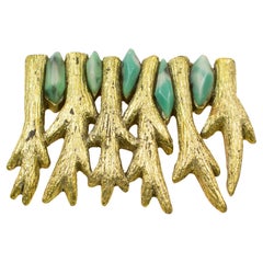 L
artista Mary Oros Spilla in resina dorata con cabochon in resina turchese