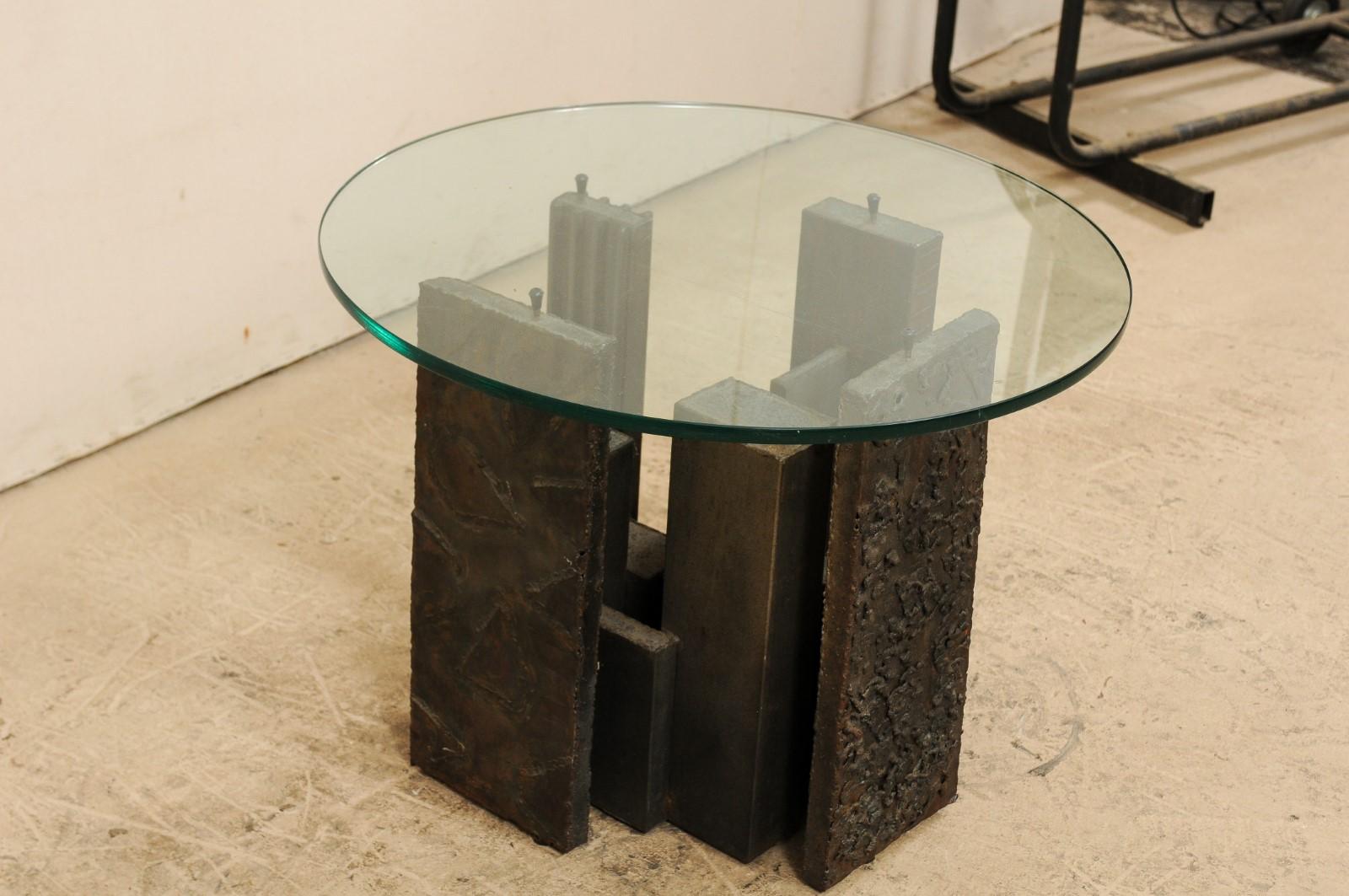 A Brutalist style sculpted side table, designed by artists Paul Evans (American, 1931-1987) for Directional furniture, circa 1970s. This vintage side table has a piece of round-shaped glass which rests atop Paul Evans creation of sculpted metal