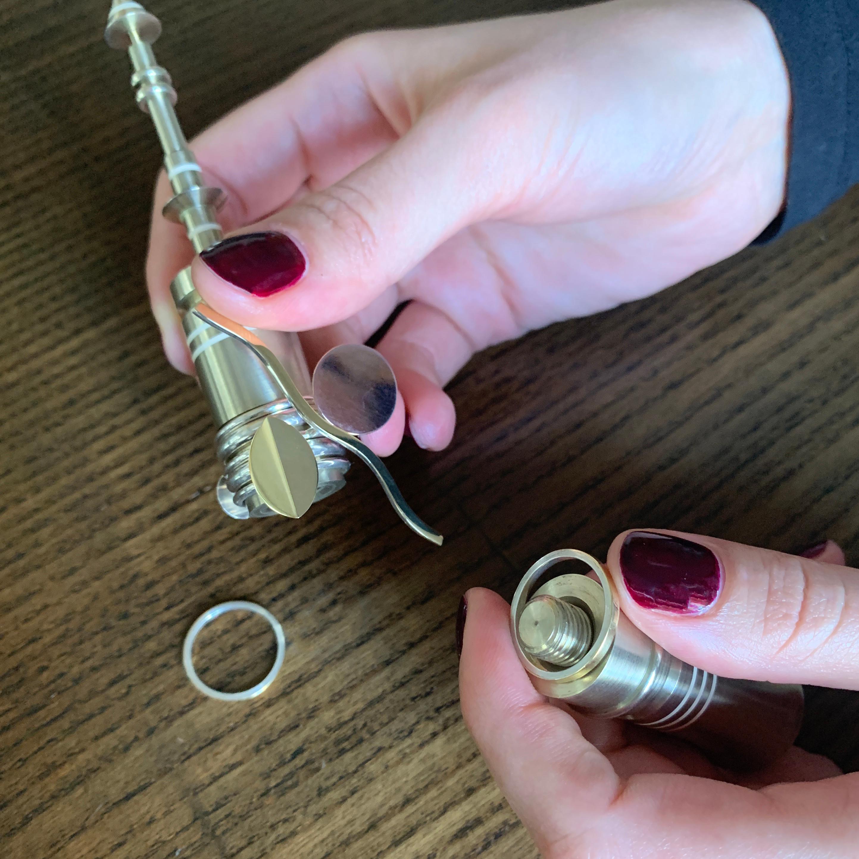 A set of seven stackable sterling silver and 18 karat yellow and rose gold rings, with fitted brass stand, by Wendy Ramshaw, 1990. The rings measure a size 7. They are stamped WR, and have London Hallmarks for 1990 dated with letter 