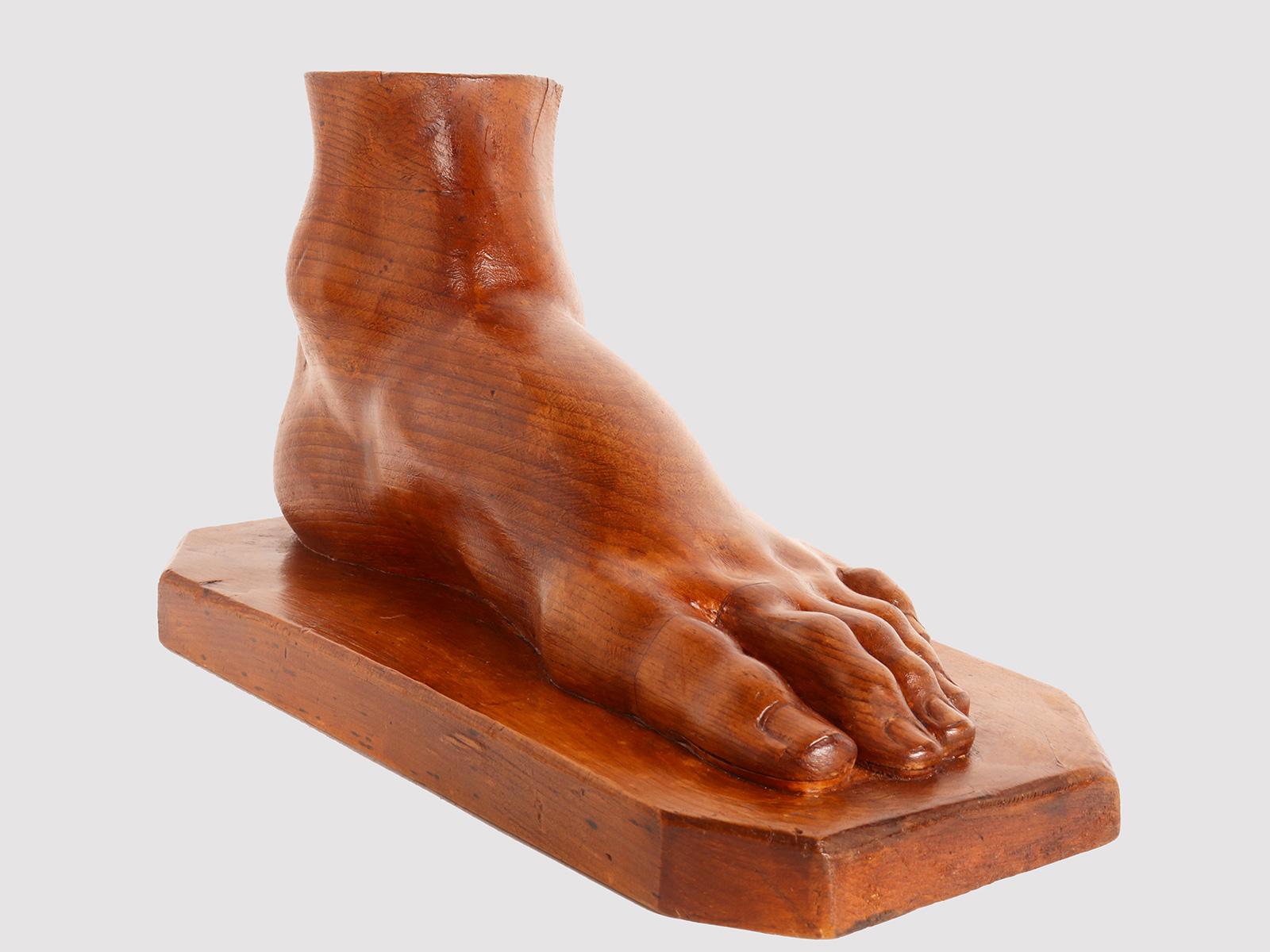 Artistic atelier sculpture depicting a foot. Made of fruit wood, the sculpture has a smooth base with an irregular geometric edge, on which is the artist's proof of refined workmanship and realism, finished down to the smallest detail. Not like in