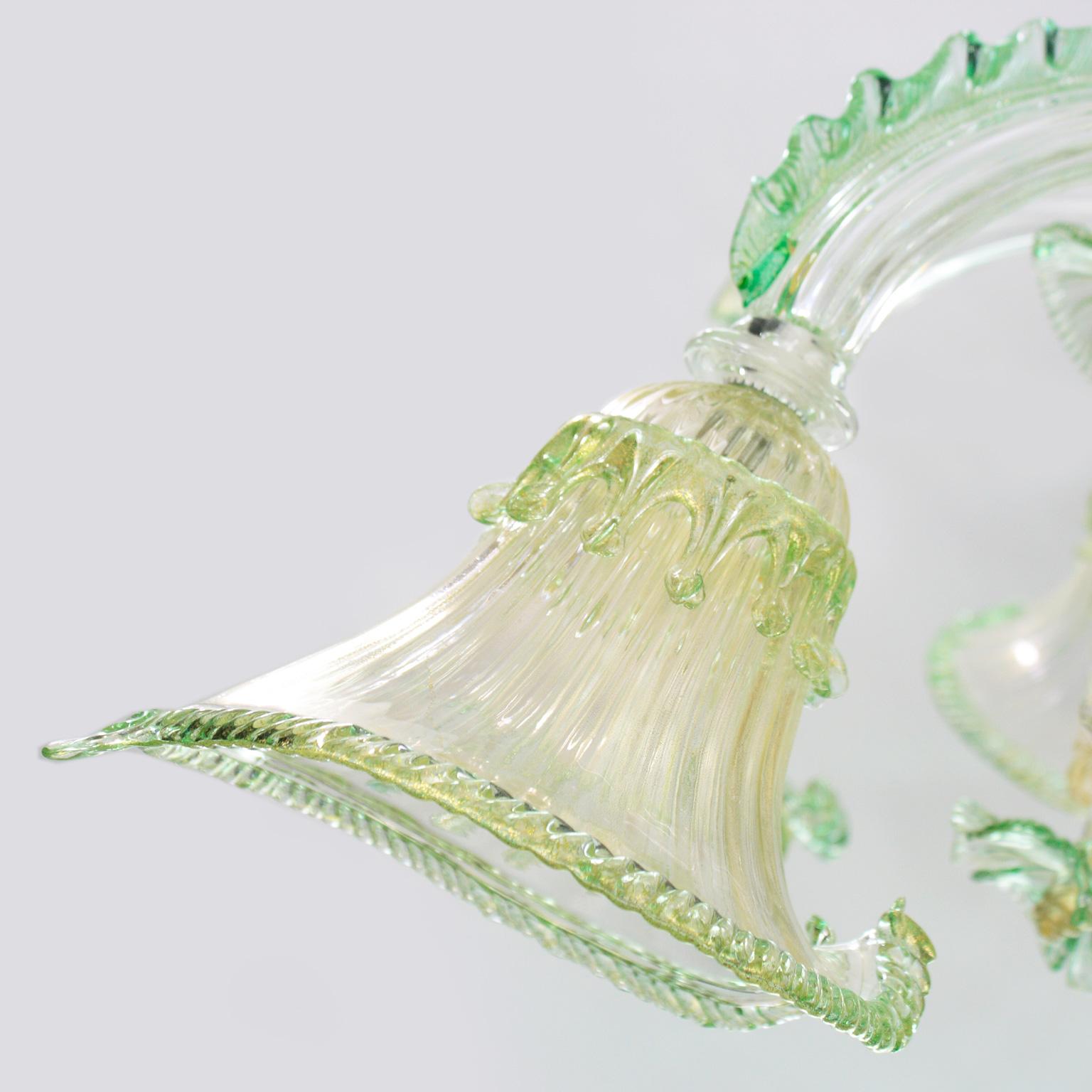 This Venetian ceiling lamp in crystal, green, gold artistic Murano glass presents an organic design, which is the result of an inspiration taken from the nature. The cups and some details remind the fluid flow of the water, a vital element which