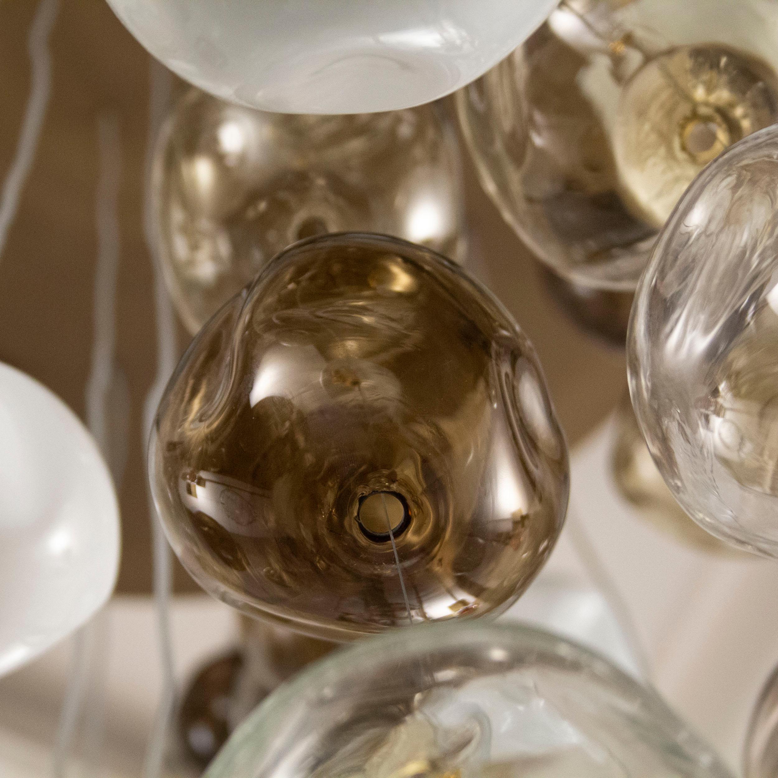 Elegant and unmistakable, suggestive and poetical, soft and delicate are some of the adjectives that can be used to describe the blown glass ball chandelier Desafinado, our ceiling light with hand-blown glass spheres.

This item consists in a new