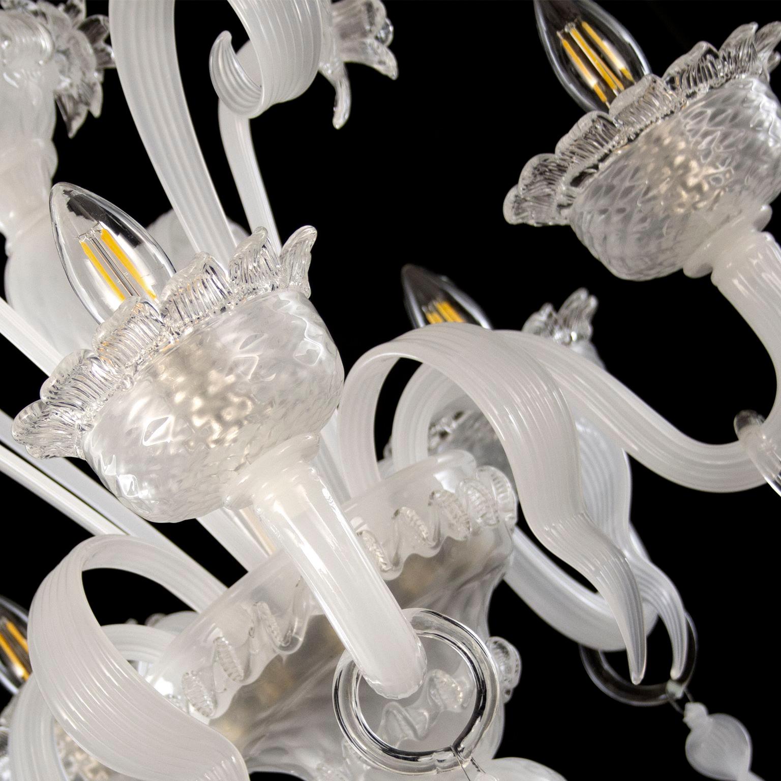 Artistic chandelier 5 arms in white silk Murano glass and clear details Springtime.
The peculiar characteristic of this lighting work is the richness of its decorations. 
Springtime reflects the authentic Murano glass tradition, which has become
