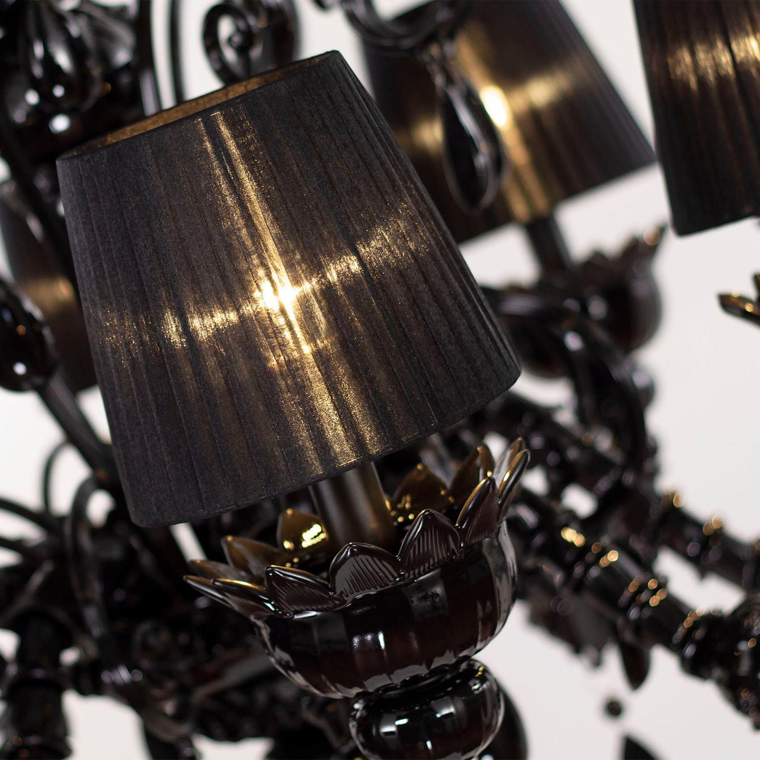 Montecristo chandelier 8 arms, artistic black glass, black organza lampshades by Multiforme.
Montecristo collection is created with the typical elements of Venetian glass chandeliers. From the central column, decorated with “morrise” and roses,