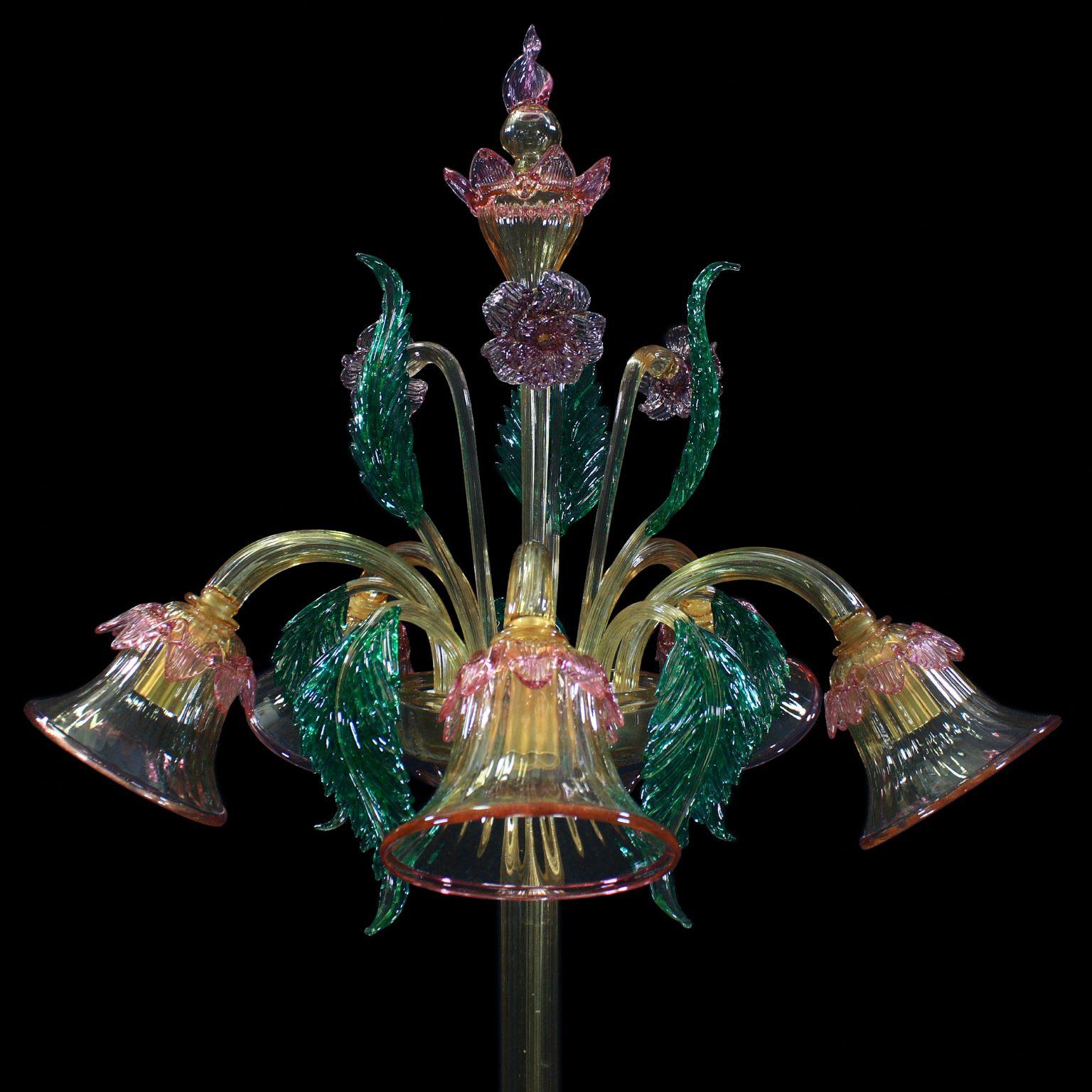 Lámpara de pie artística, 5 luces, de cristal de Murano soplado color ámbar, con elementos ornamentales y flores de color rosa, verde y azul claro, de Multiforme. Los brazos están hacia abajo.
Inspirada en la tradición clásica veneciana, se