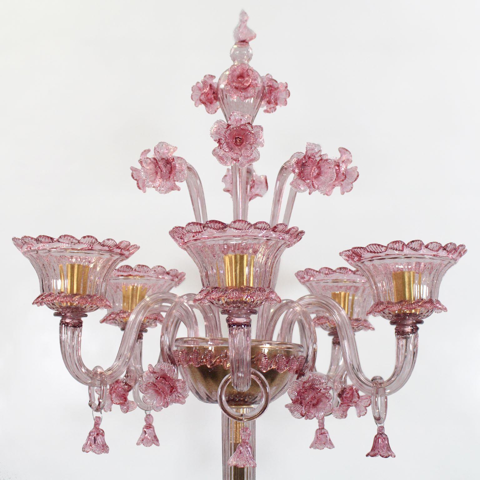 Artistic floor lamp, 5 lights, in amethyst blown Murano glass, with pink ornamental elements and flowers by Multiforme. The glass cups are upwards.
Inspired by the Classic Venetian tradition it is characterised by a central column where many blown