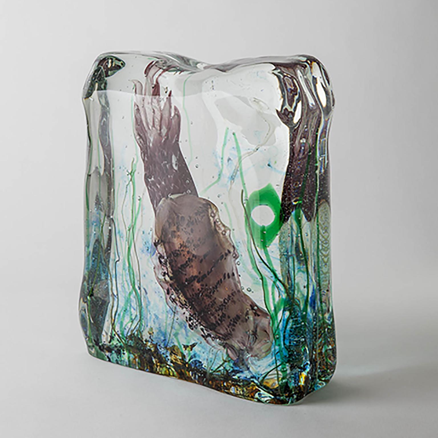 Élevez votre espace avec cet aquarium exquis en verre de Murano, fabriqué de manière experte en utilisant la technique sommerso. Ce processus complexe consiste à souffler un sujet détaillé dans le verre, qui est ensuite immergé dans du verre