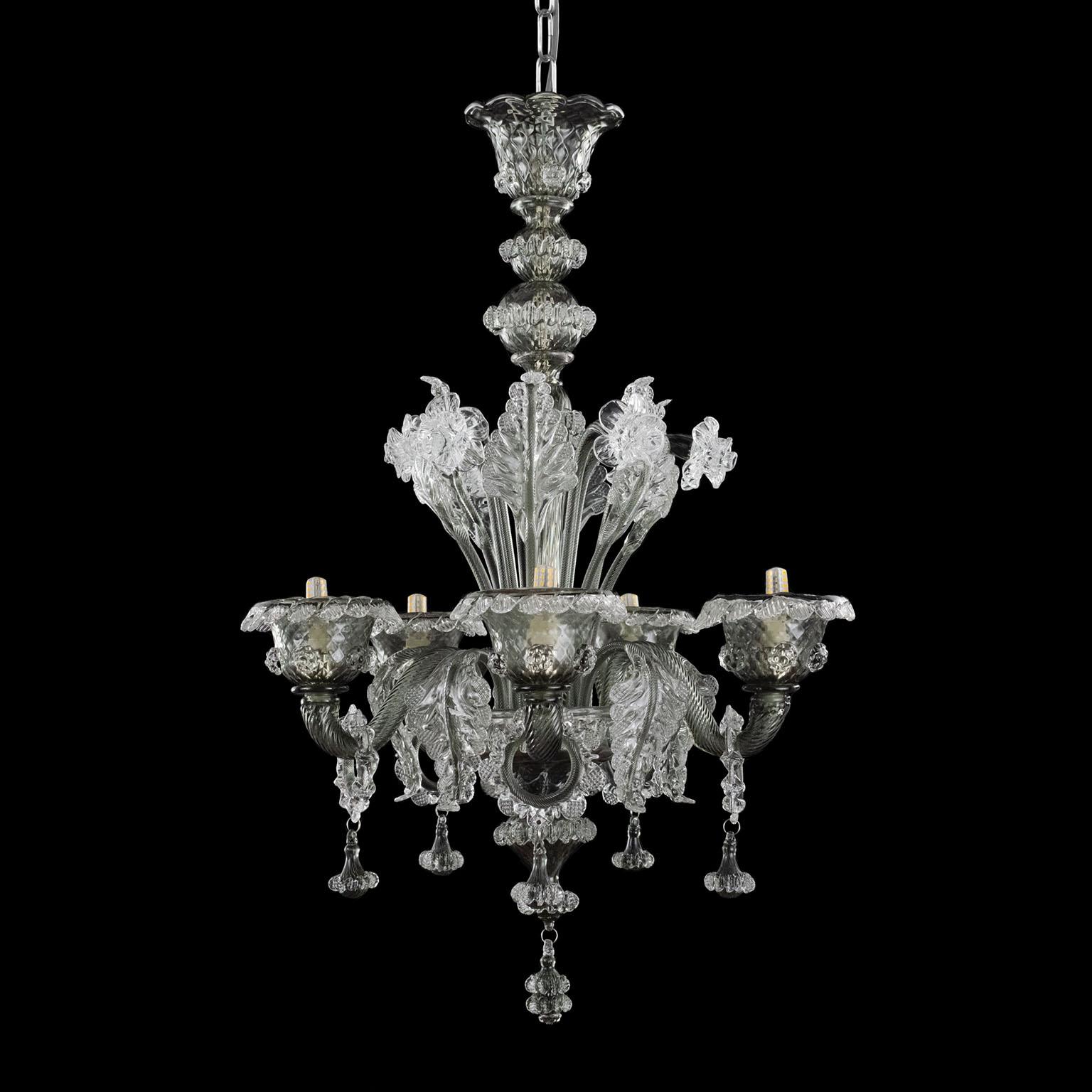 Galliano chandelier, 5-light, clear and drak grey Murano glass by Multiforme.
This artistic glass chandelier has 6-light, is handmade in crystal and dark grey Muarno glass.
Galliano is our tribute to the authentic Murano glass tradition. It requires