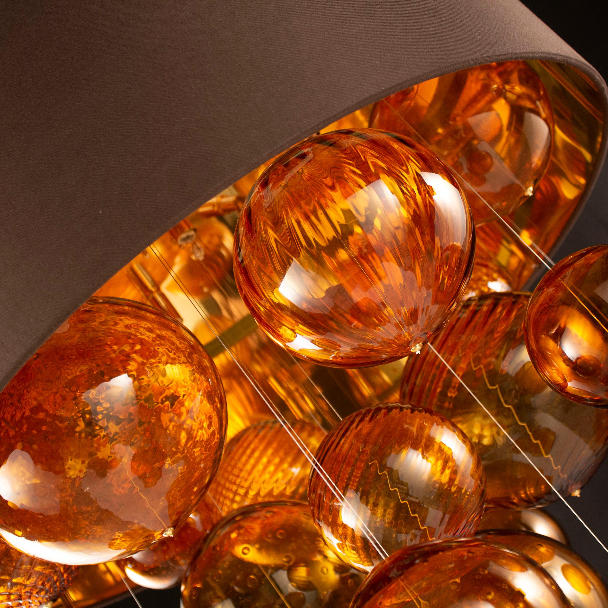 Absolute suspension lamp with brown cotonette lampshade and amber artistic glass elements by Multiforme. Polished gold frame. The artistic glass, design chandelier. It consists in a suspension lampshade inside which the light bulbs are hidden and a