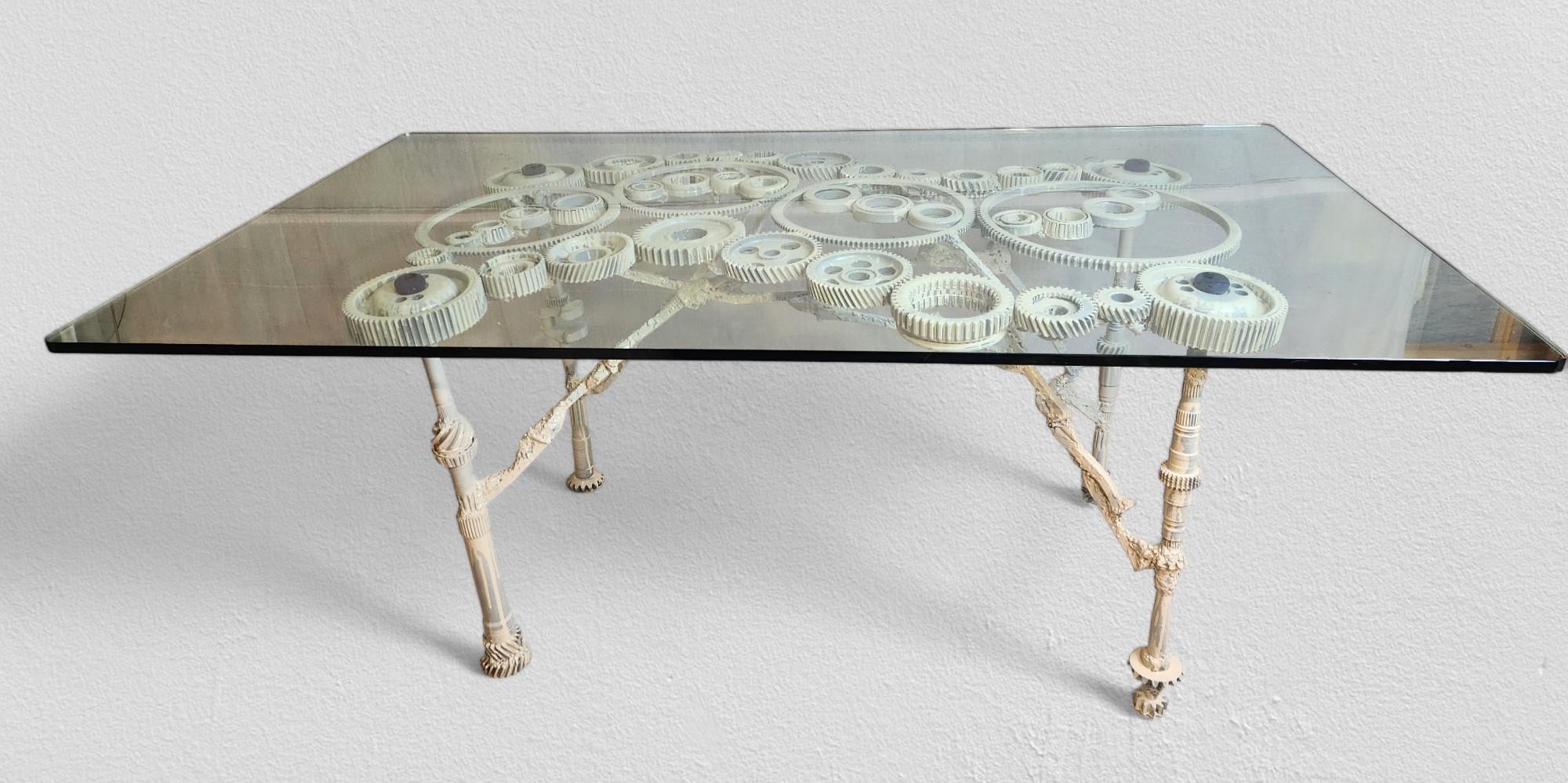 A studio crafted table created in the 1970s from an interesting and unique selection of cast iron gears, sprockets, and various splined drive shafts artistically coupled with a cross stretcher of slag welded spikes attributed to the American
