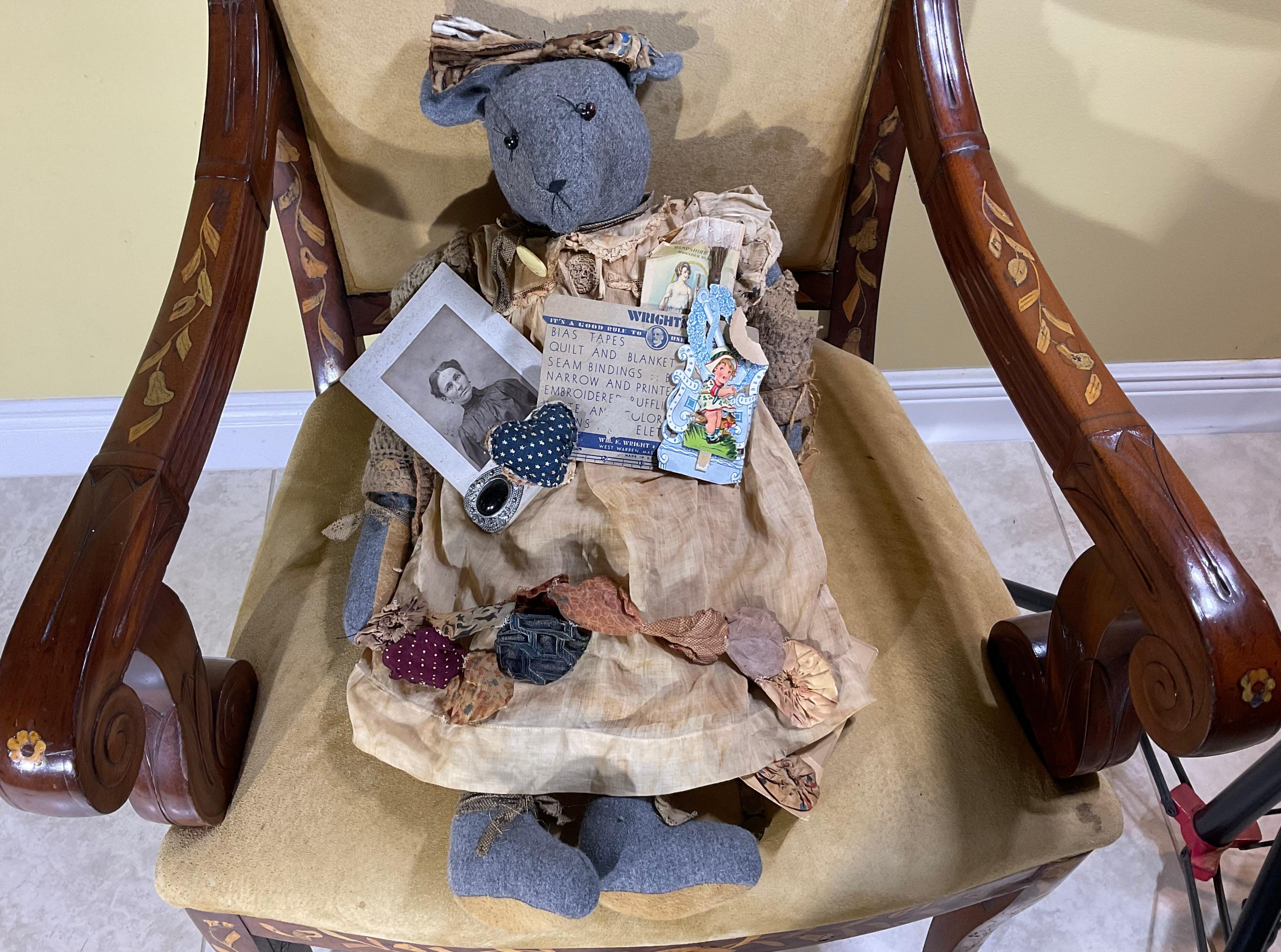 American bear from the 20th century , the bear is nicely hand made with old fabric and have  revealing its great use.  the bear wearing kind of accessories including bracelets, old postcard, label, vintage photo and brooch on the dress  , very