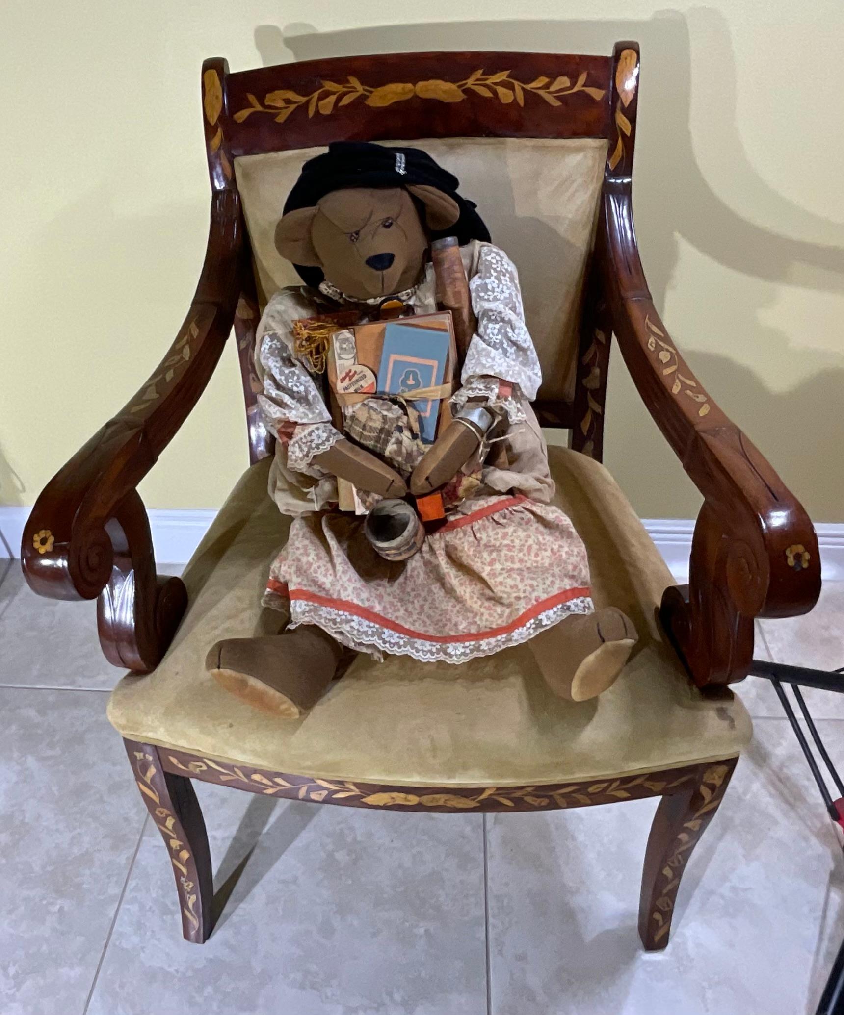 American bear from the 20th century , the bear is artificially hand made with old fabric and have  revealing its great use.  the bear wearing kind of accessories including ,book, old postcard, label, vintage photo and brooch on the dress  ,and nice