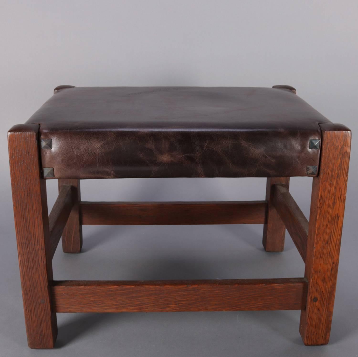 Arts and Crafts Mission oak footstool by Gustav Stickley features traditional simple form with pegged construction, faux leather upholstery and pyramid upholstery tacks, signed Gustav Stickley, circa 1910

Measures: 15