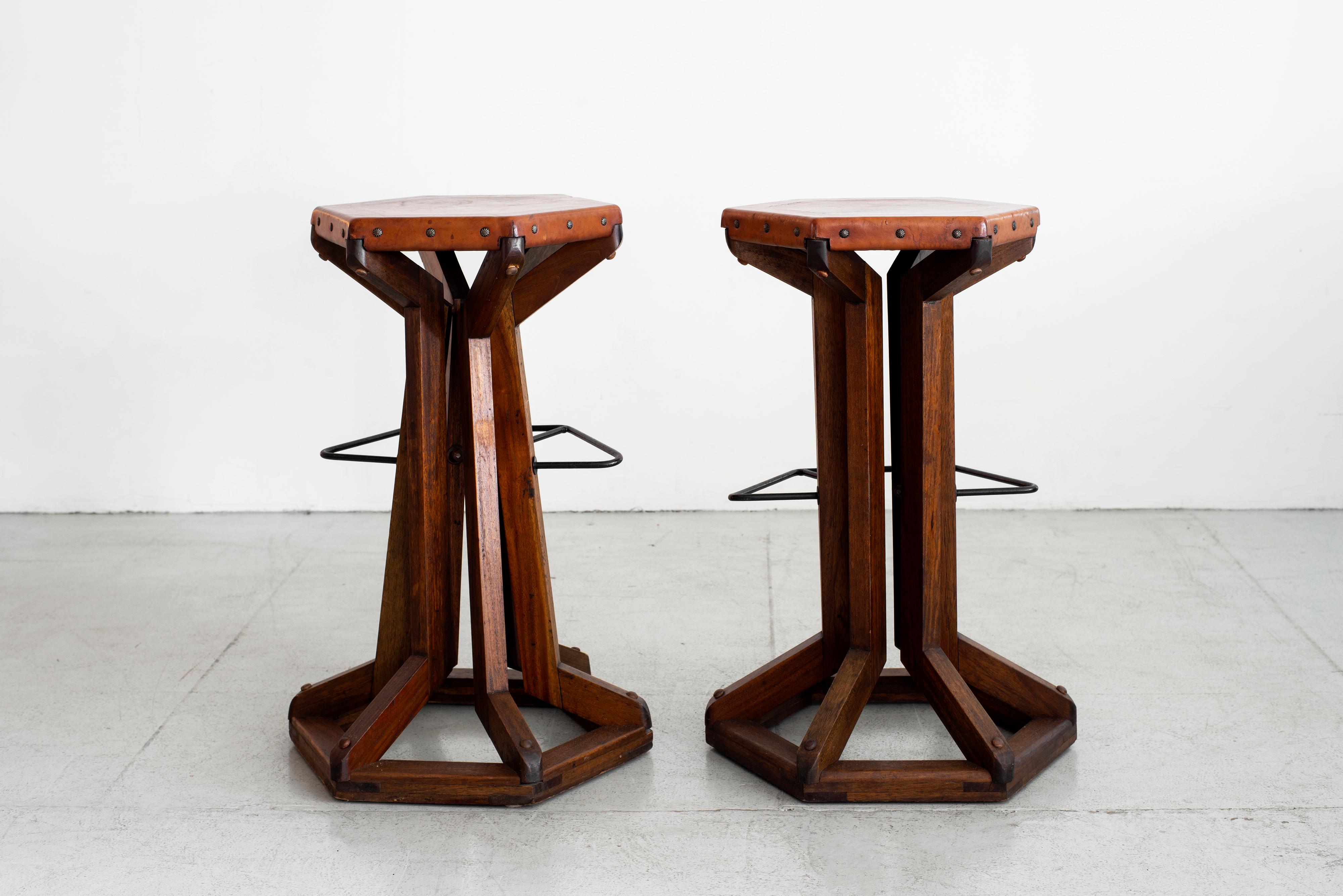 Unique pair of Arts & Craft bar stools with hexagon leather seats, brass tacks and iron metal foot stool. Great patina to wood and wonderful overall craftsmanship.