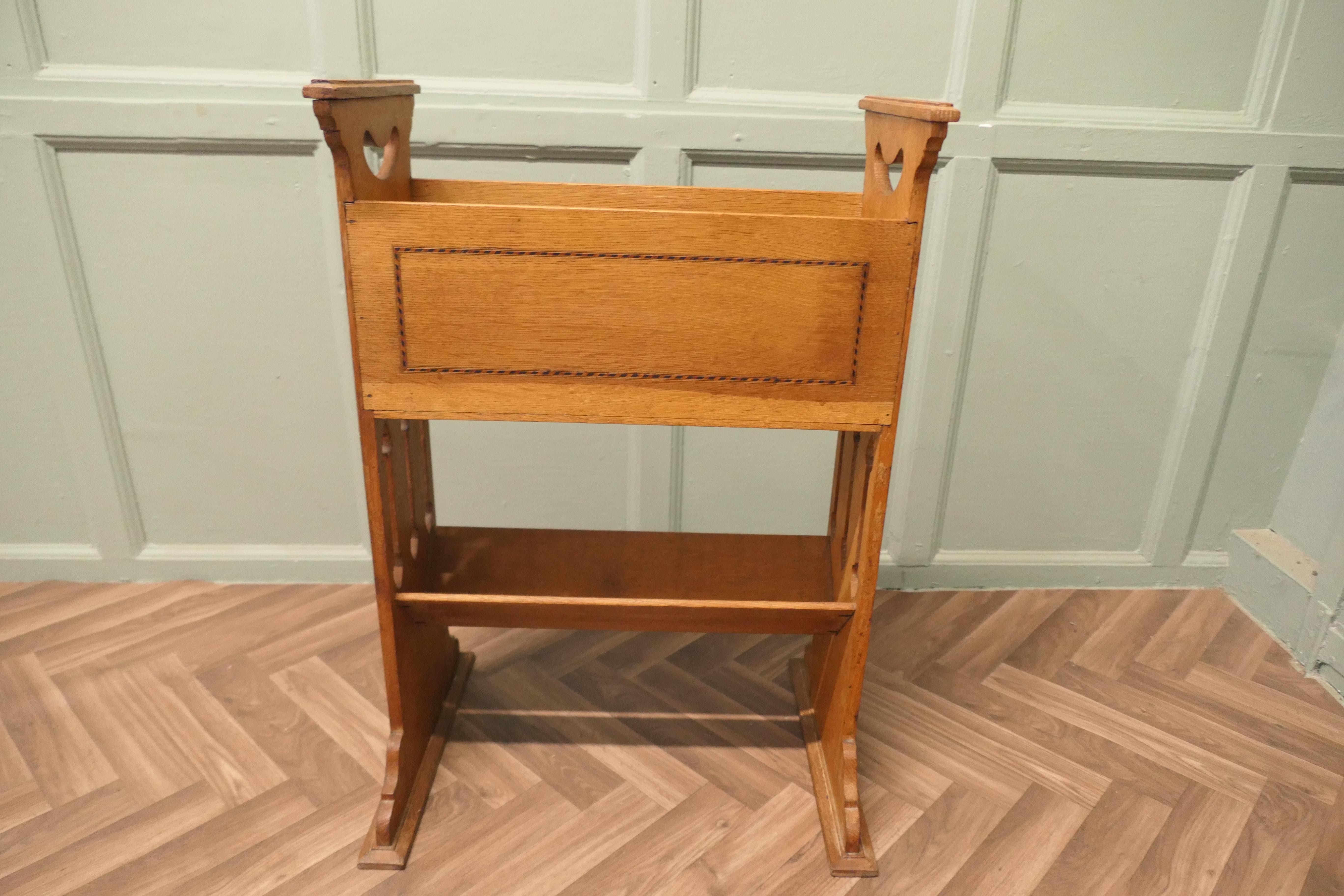 Arts and Crafts 2 Tier Golden Oak Bücherregal 

Dieses Bücherregal aus Eiche hat 2 offene Regale, das obere ist ein tiefes Ablagefach und das untere ist eine schräge Bücherwanne 
Das Regal hat geschnitzte Griffe an jeder Seite
Das Bücherregal ist in