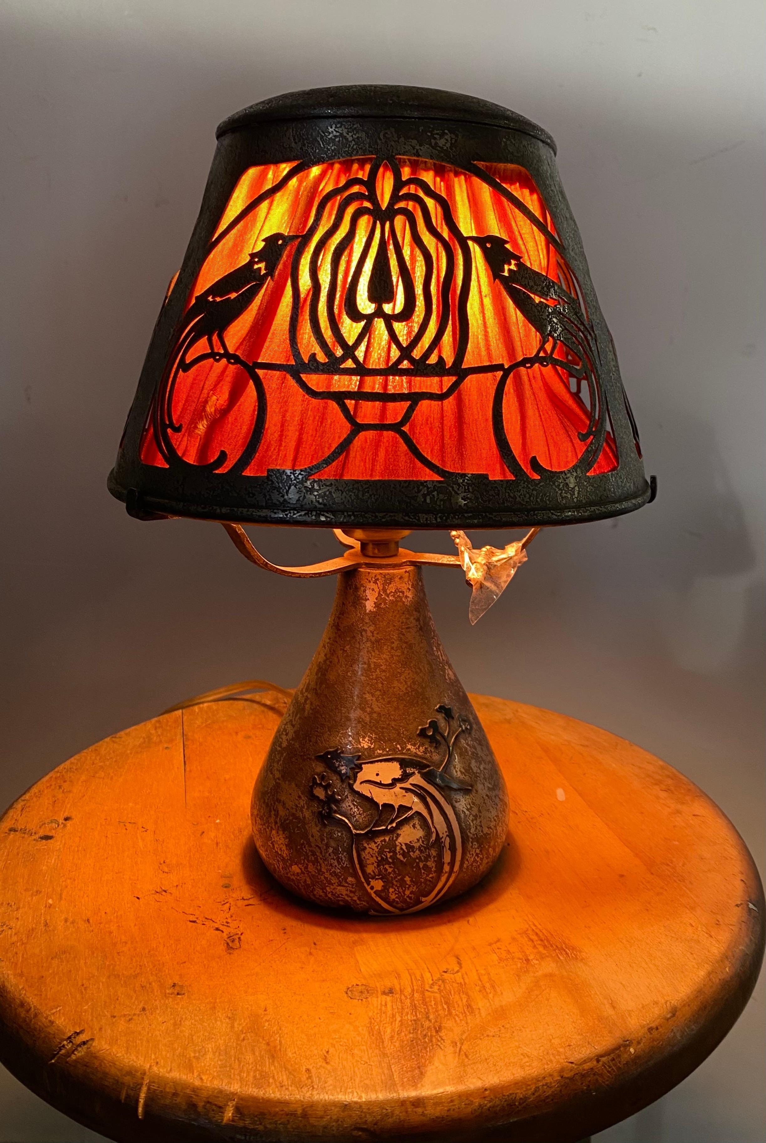 Classic Arts & Crafts /American mission lamp. Heintz art metal, silver over bronze, retains original fabric under filigree shade, bird motif, also retains original foil label.