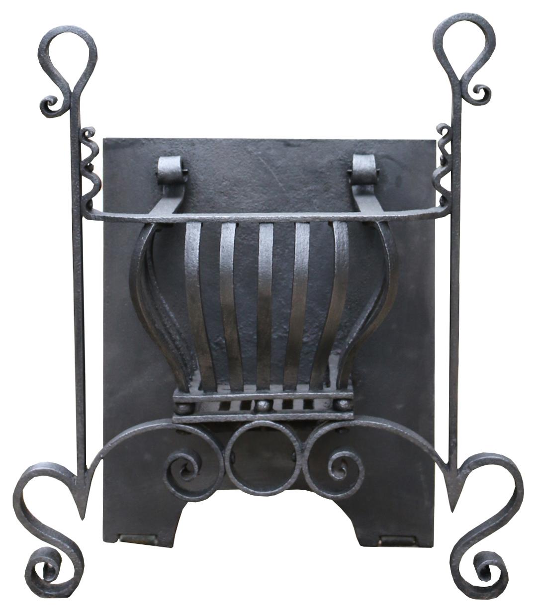 An English Arts and Crafts Movement fire grate. Blacksmith made, with scroll decoration.
