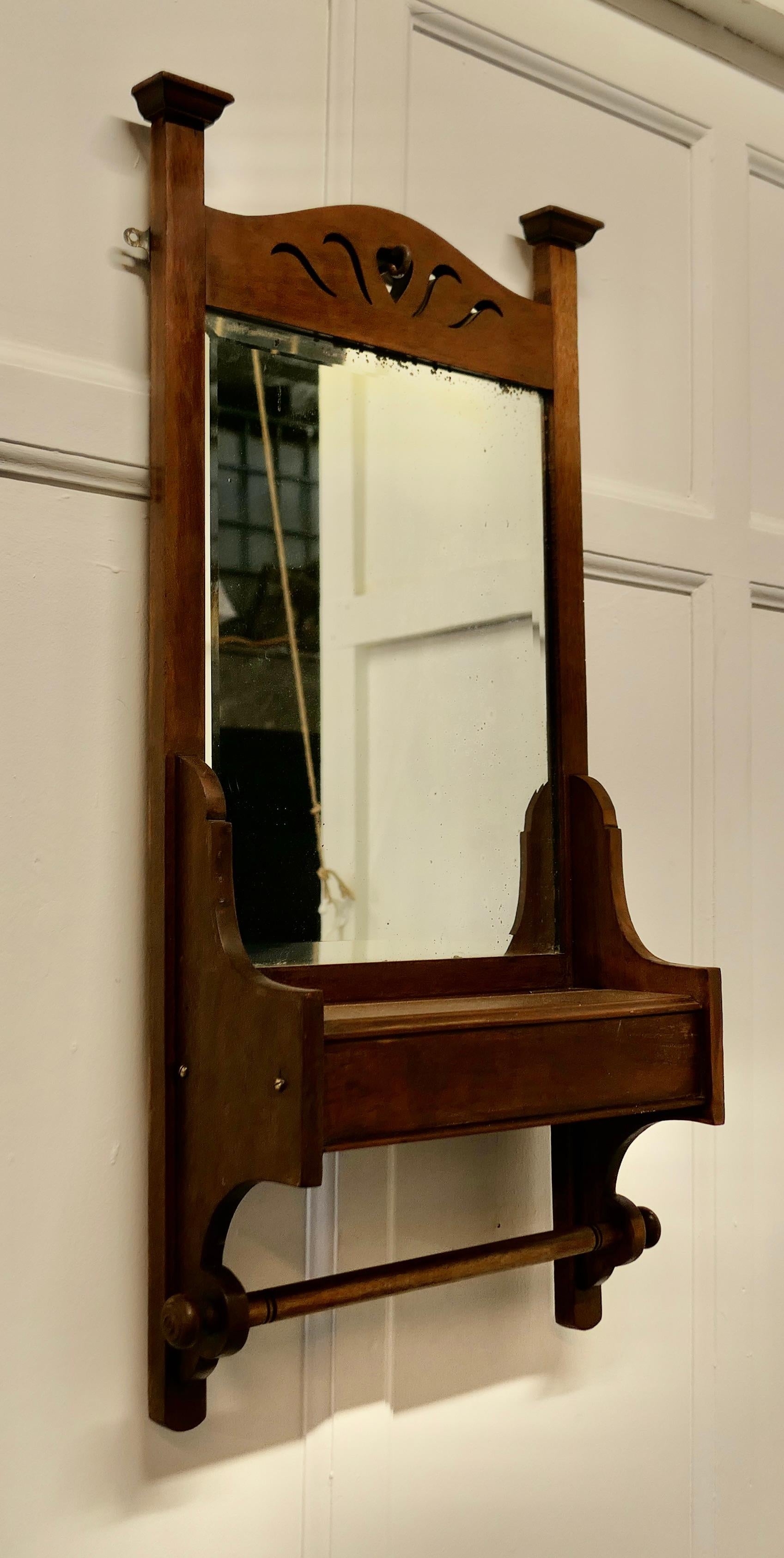 Arts and Crafts bathroom wall mirror with towel rail

This is a very attractive piece, which would work very well in a bathroom or cloak room
The mirror has a small shelf beneath which lifts to access a small storage box, below this there is a