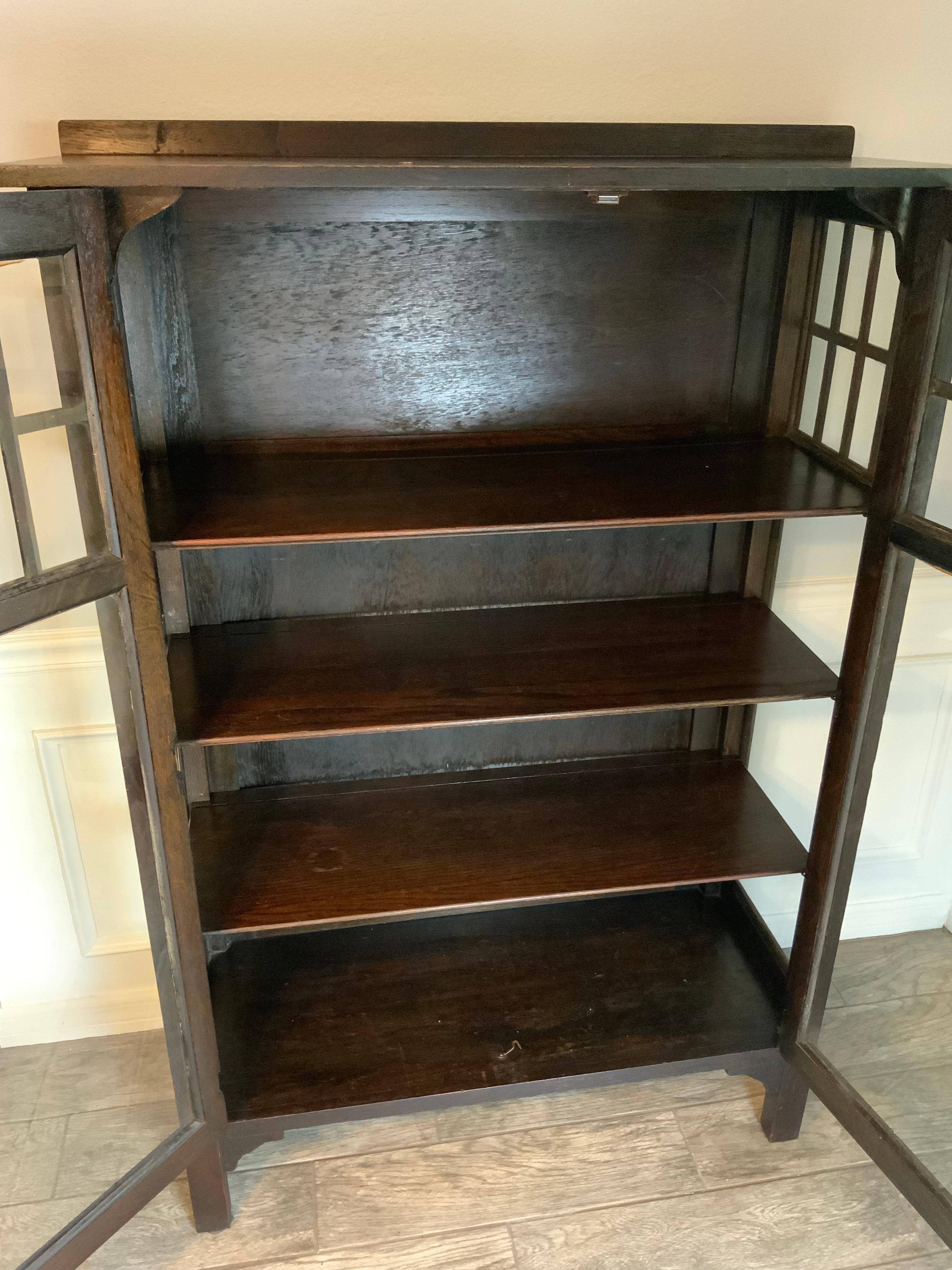 A very nice early 20th century Arts and Crafts quarter sawn Oak double door bookcase.  One pane of glass on the side is a later replacement, all others are the original wavy glass.  Original dry varnish surface with an excellent color and patina.