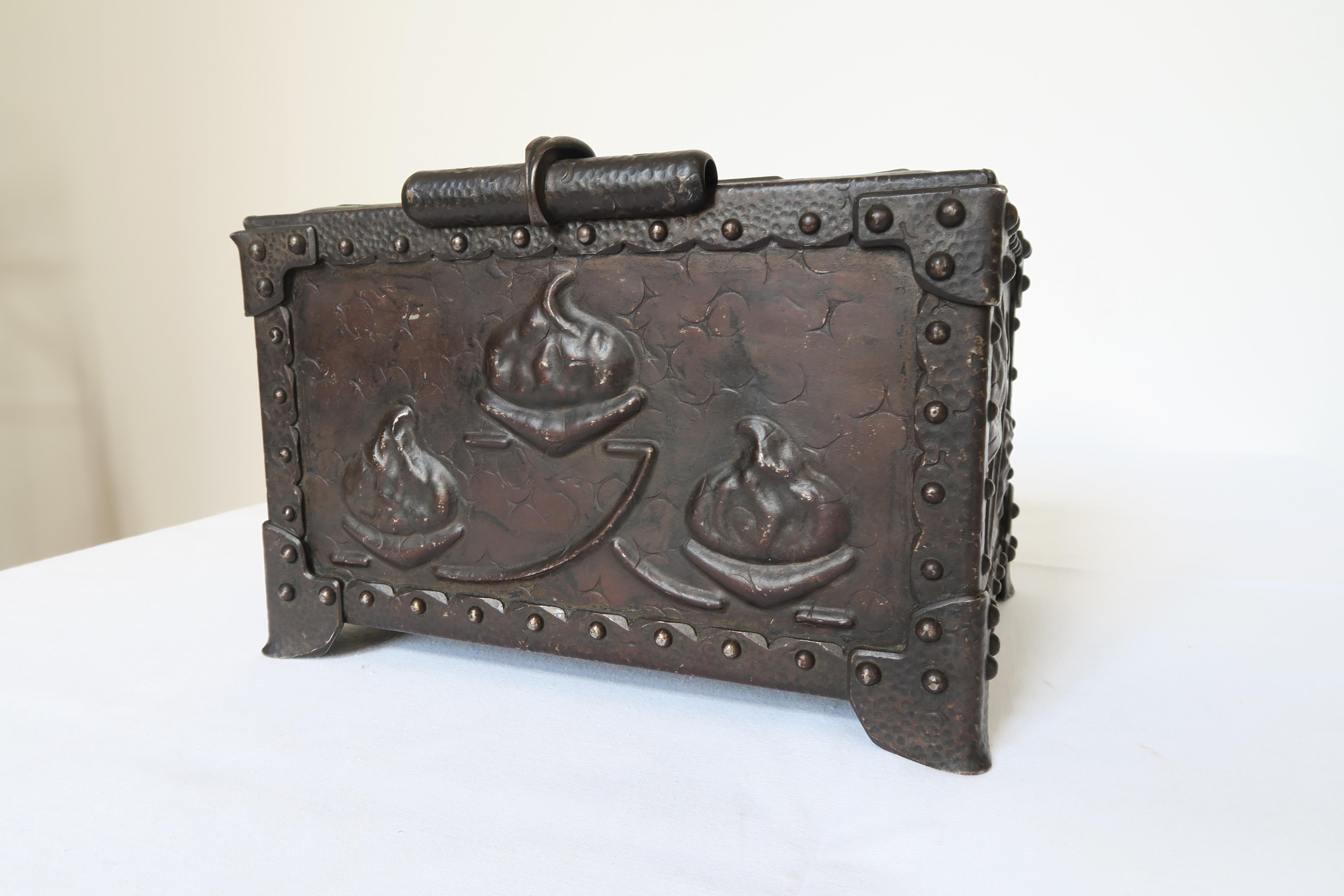The item on sale is an iron chest or casket suitable for arts and crafts or as a decorative object. It might have been made in Germany, England or Scottland. The box has been hand crafted and embossed with ornaments resemblant of acorns or