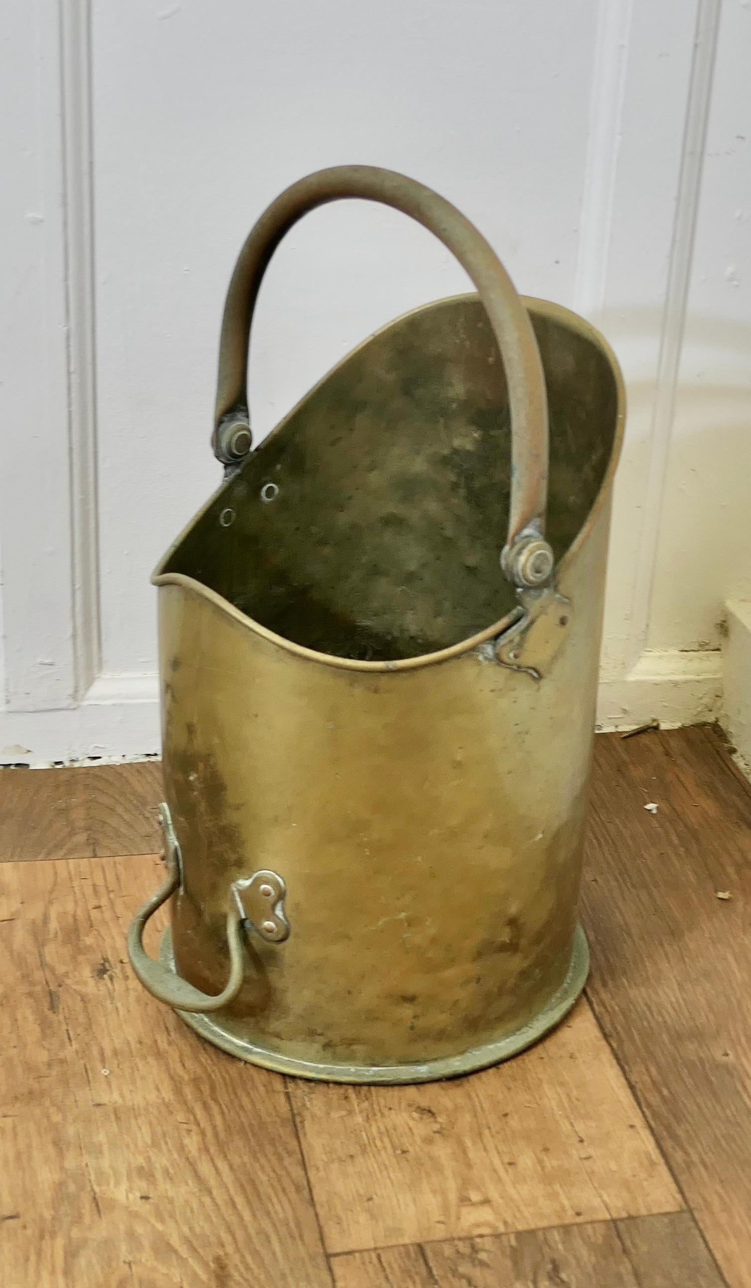 Arts and Crafts Brass Coal Bucket, Scuttle 

This bucket is a very attractive cylindrical shape, it is made in Brass with ariveted hooped swing handle at the top and a smaller brass handle at the back
The Scuttle is in good used condition, it has a