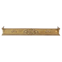 Arts and Crafts brass fender adorned with embossed floral decorations