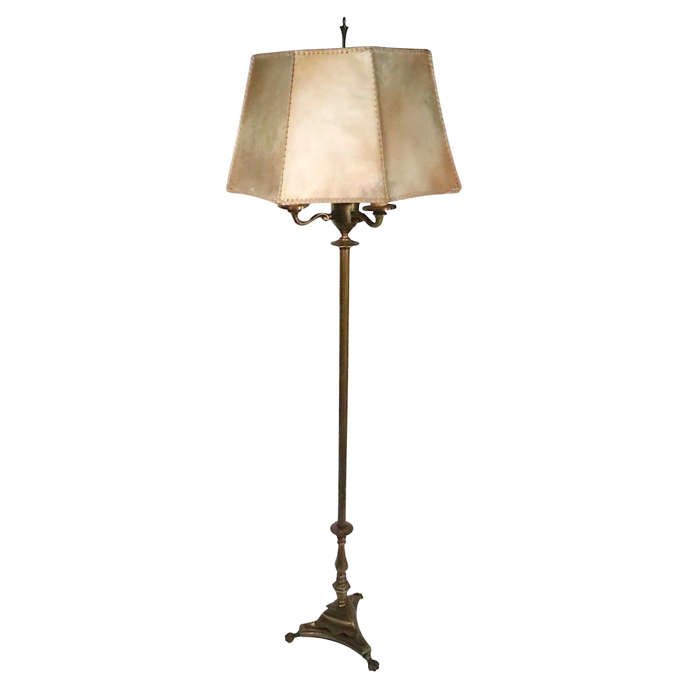 Exceptional brass floor lamp with original hide skin shade. The lamp feature a heavy cast brass base, with a four socket light cluster, glass diffuser, and octagonal paneled shade. The light cluster has a large mogal bulb on the center, with three