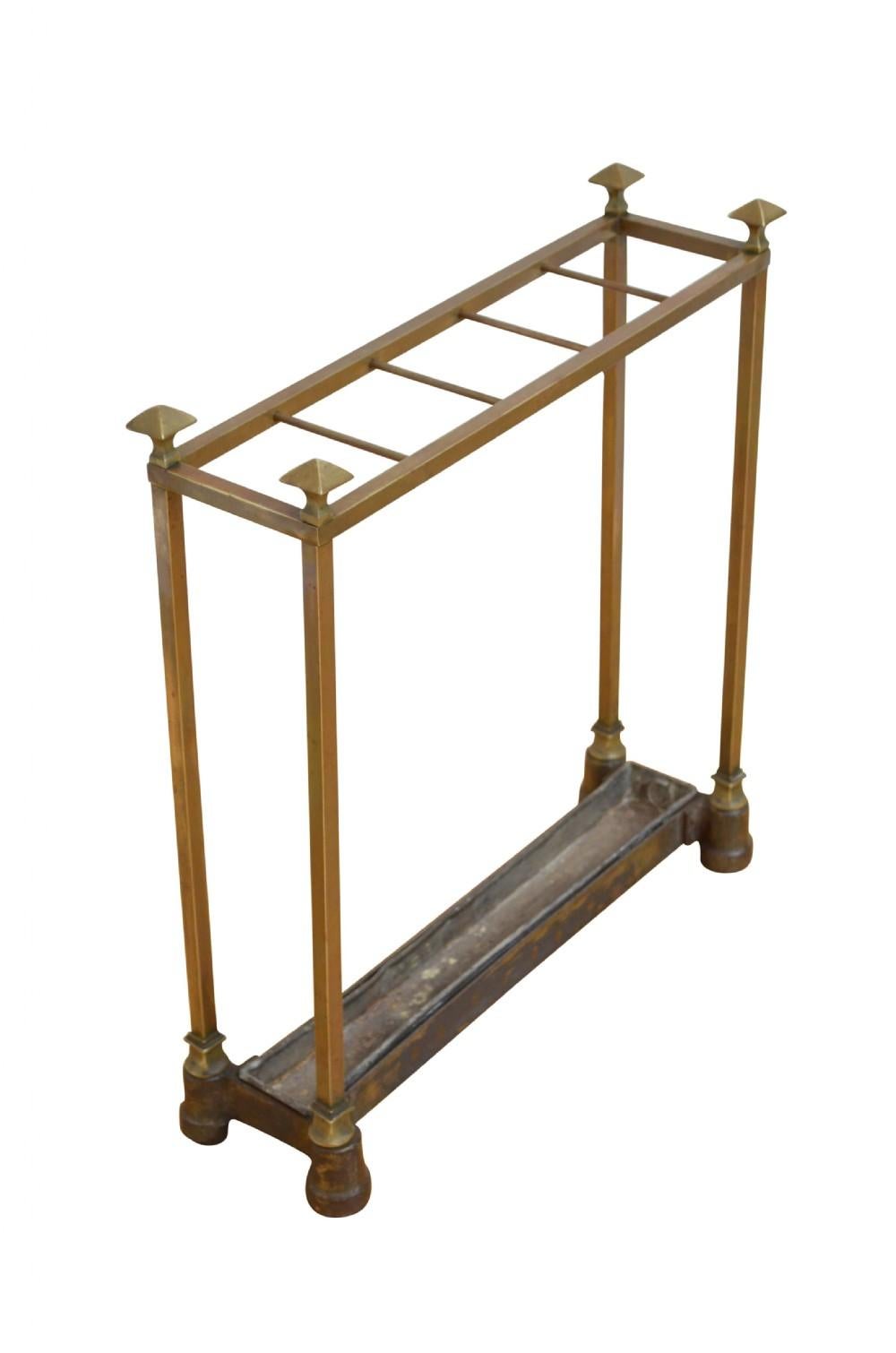 K0529 Unusual and rare Arts and Crafts brass umbrella stand with five divisions flanked by decorative finials, cast iron base and removable drip tray. This antique umbrella stand retains its original patina, all in country house condition, ready to