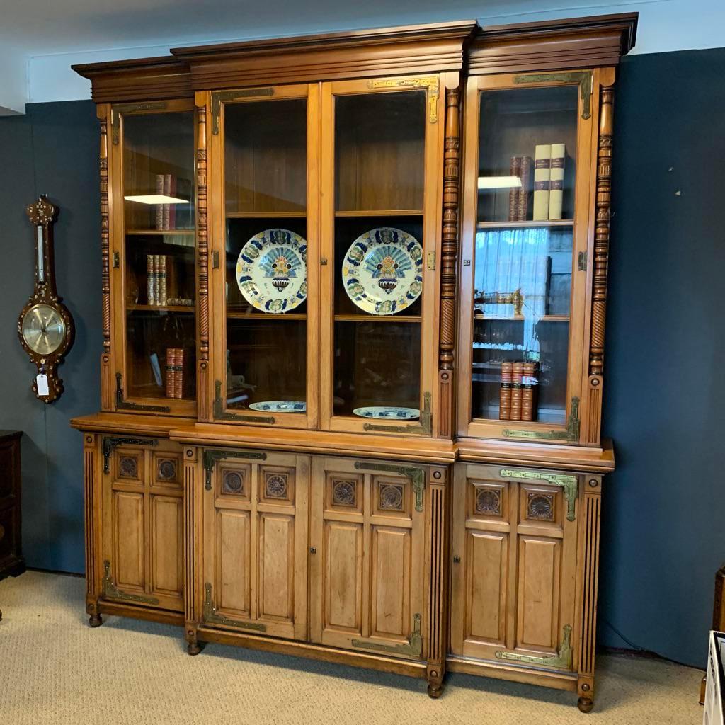 A walnut breakfront bookcase in the manner of Charles Bevan with carved details and fine turned columns, highlighted with ebonised details. Wonderful original brass hinges of the highest quality throughout, possibly by Lamb of Manchester,
circa