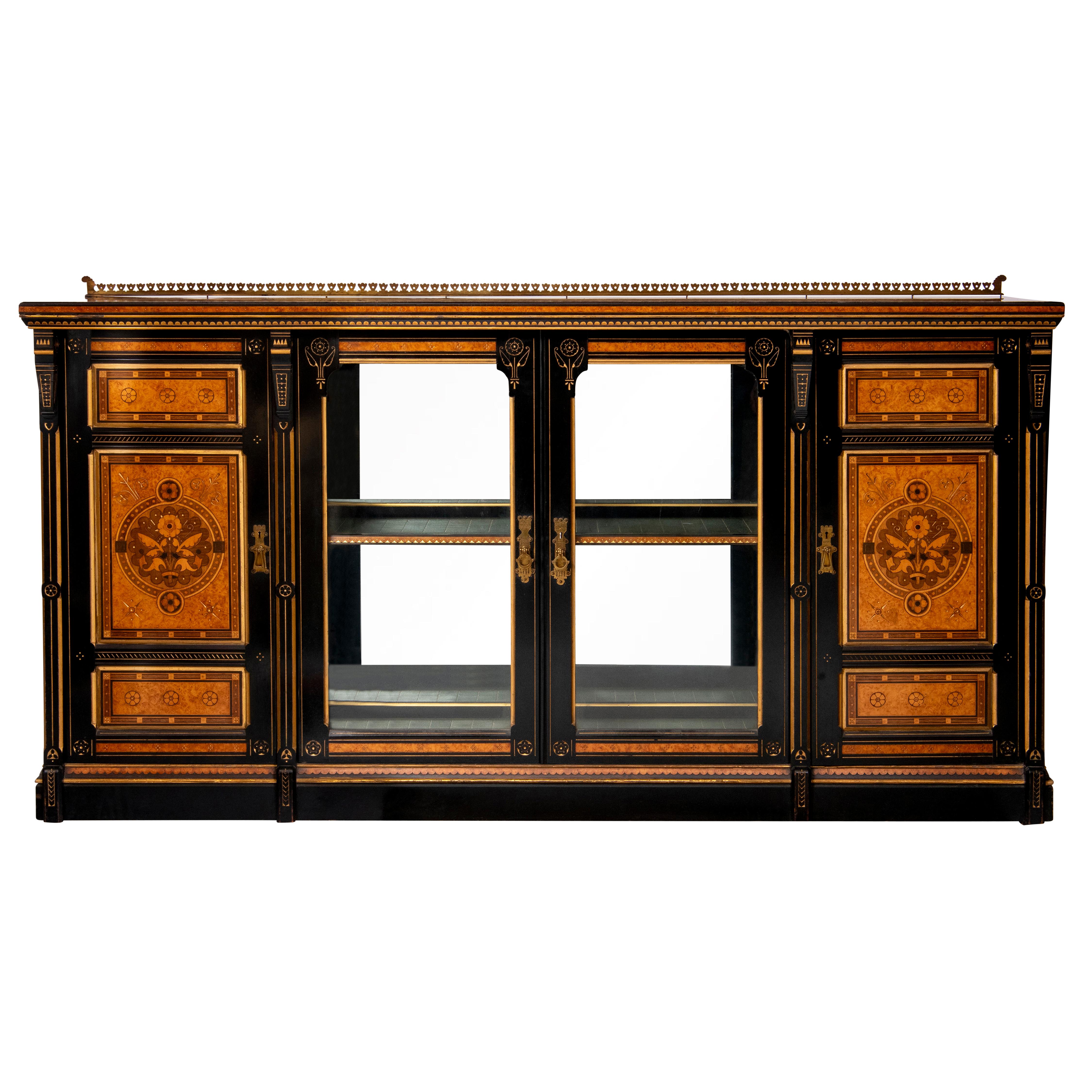 Ein Kabinett in Ausstellungsqualität von Lamb of Manchester.

 Amboyna, ebonisiert, Purpurholz, Fruchtholzintarsien und Paketvergoldung.  

Nach einem Entwurf von Bruce Talbert.

 Mit eingeschnittenen und gesplitterten Rauten-, Linien-, Lünetten-