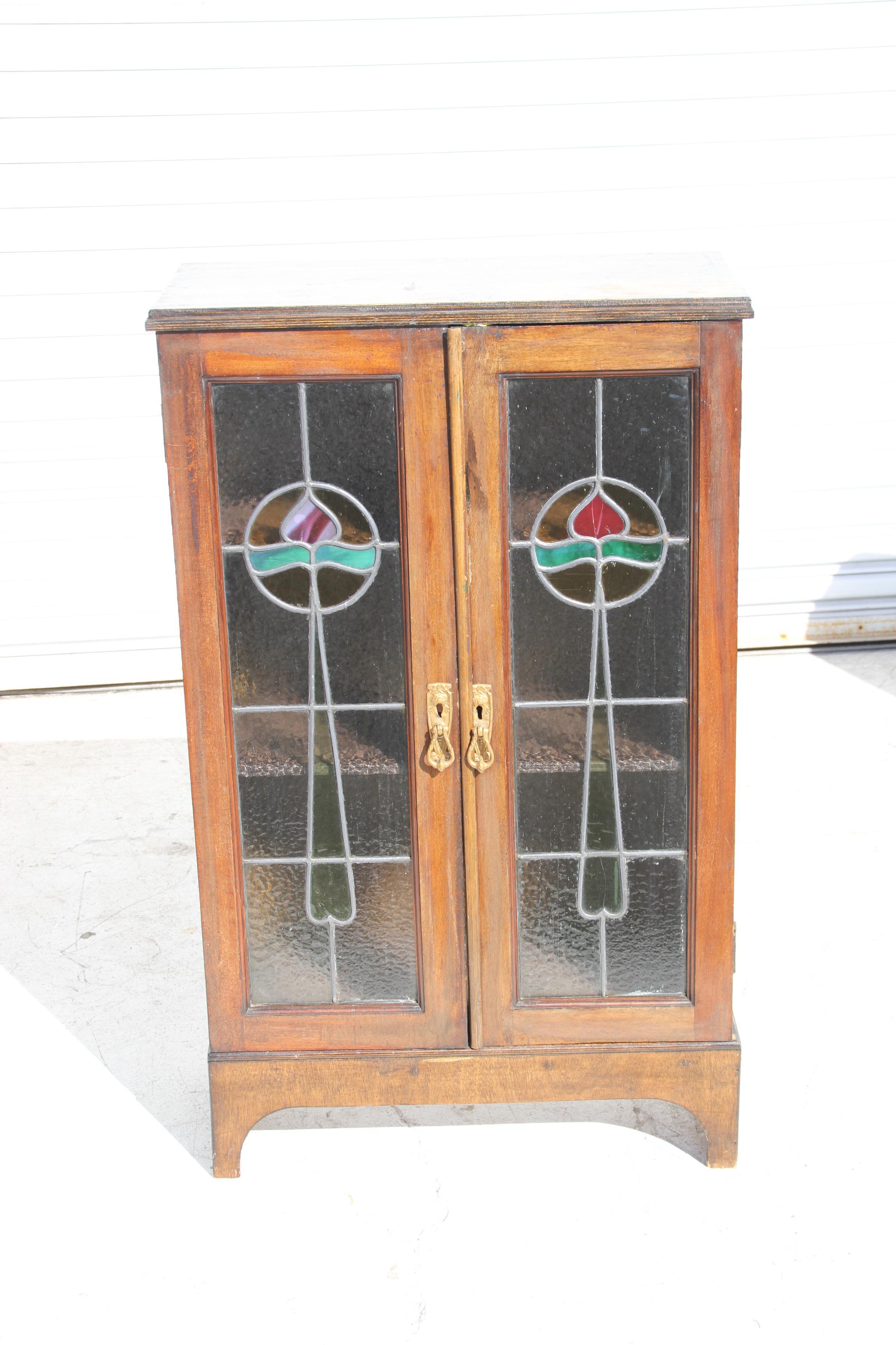 Arts and crafts stained glass cabinet

 
 An Arts & Crafts oak bookcase with stylized floral detail to the stained glass doors.
Pair of internal shelves on short square tapering legs. 


Dimensions: 24 ¼ L x 11 ¾ W x 40 H.